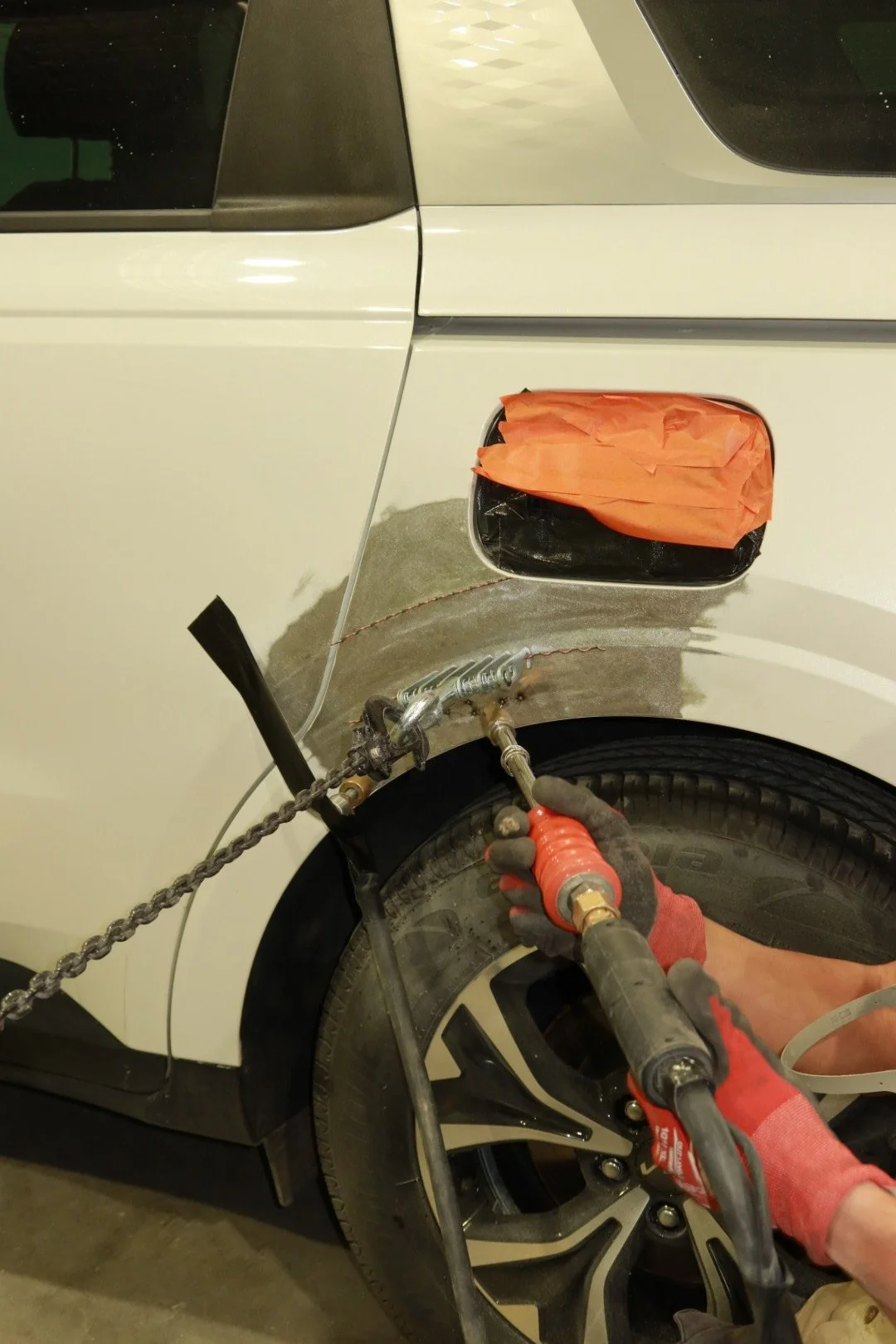 Vehicle rear quarter panel being repaired by a panel beater