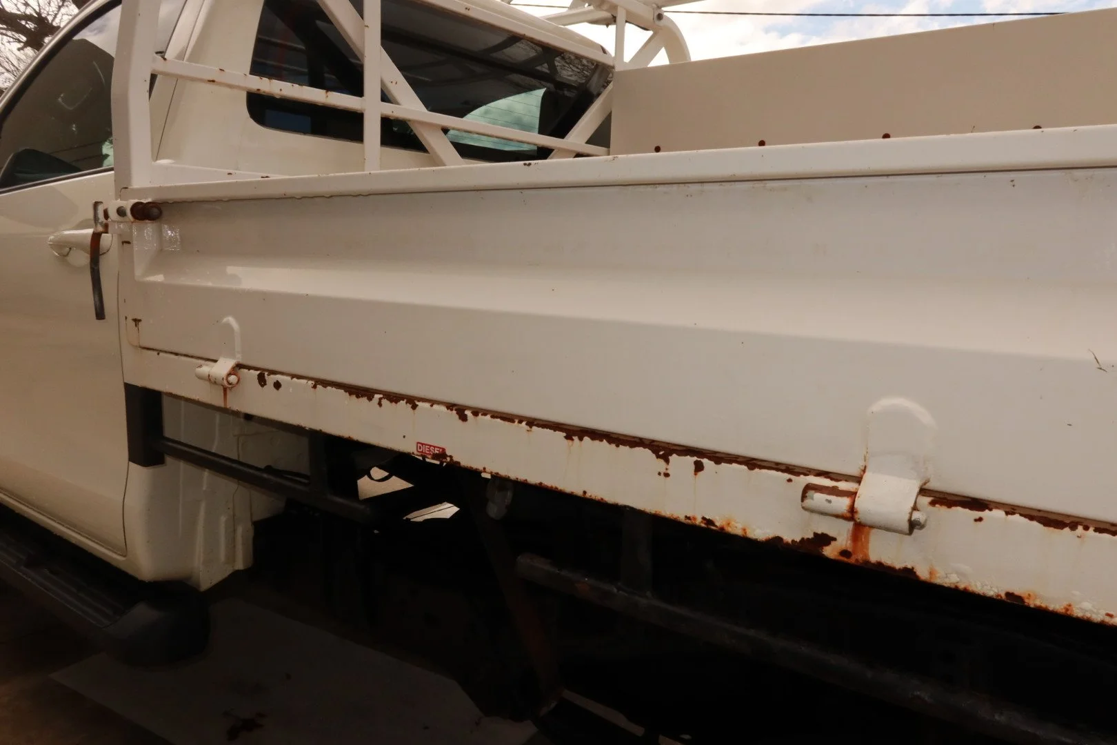Before repair – rust damage on white commercial vehicle tray