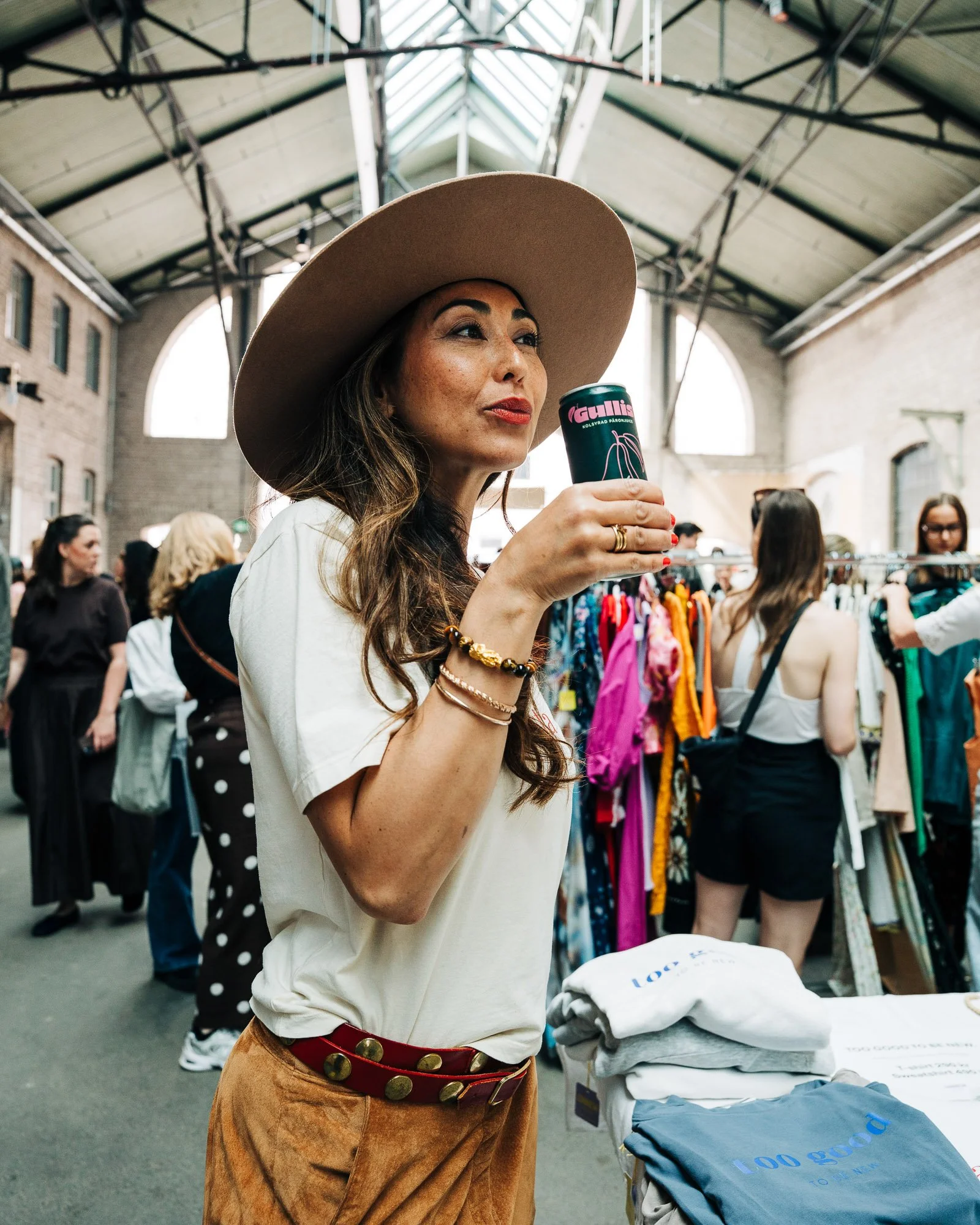 Woman holding a can of Gullis pear drink at a brand event in Stockholm