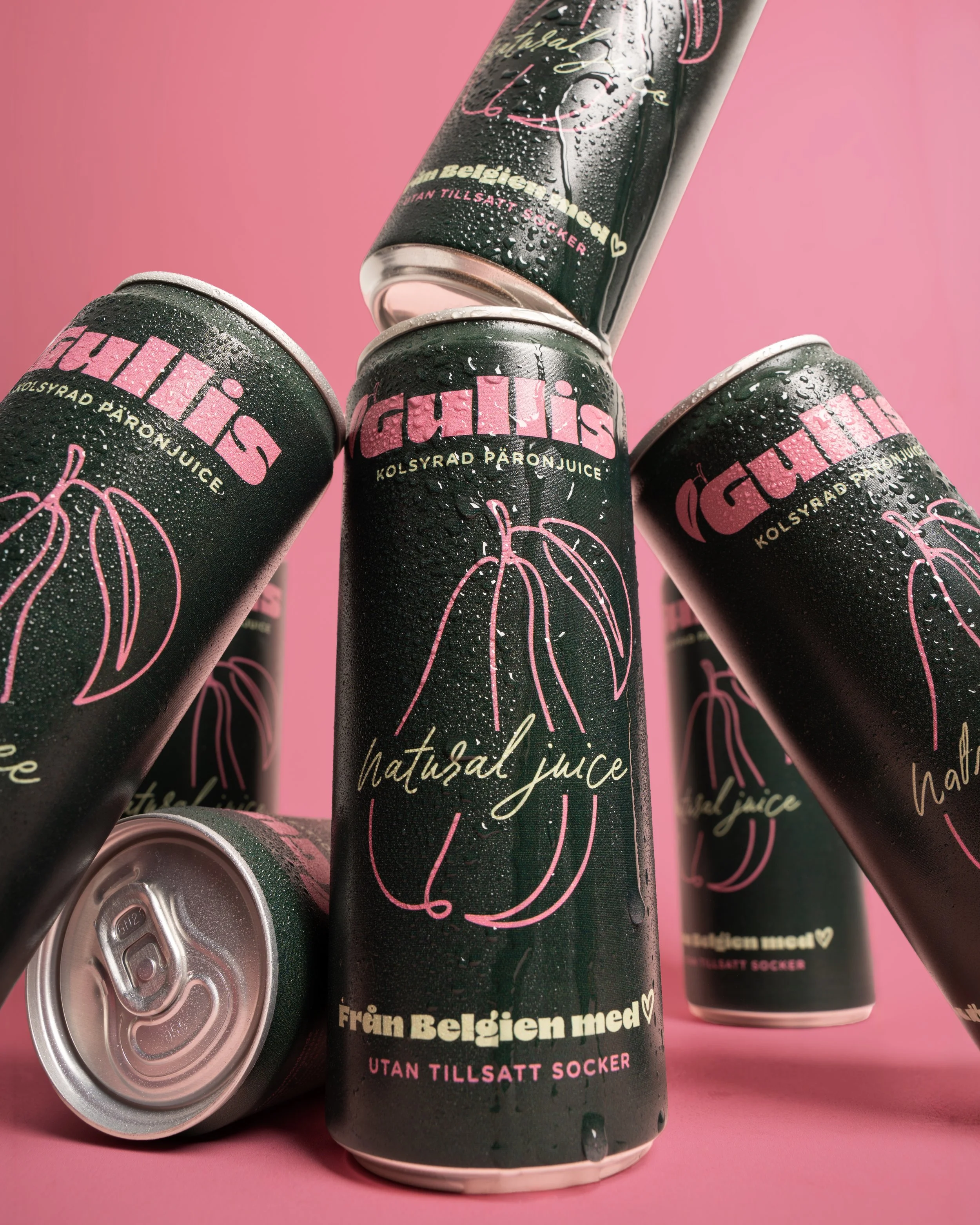 Several cans of a pink and black beverage with condensation on the outside, featuring a pink outline of a pumpkin and Swedish text, placed on a pink background.