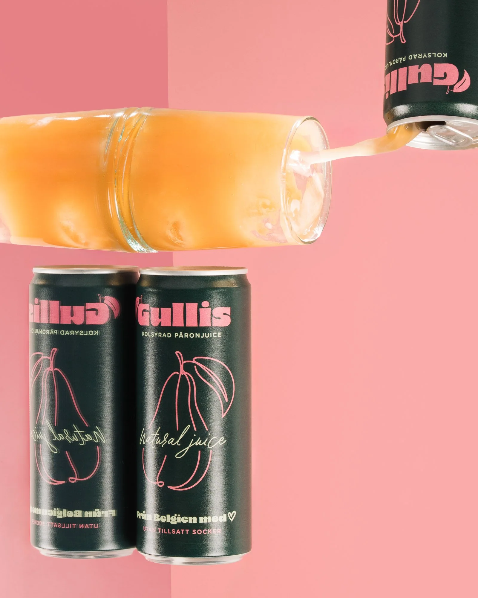 Two cans of pink grapefruit juice standing on a pink background, with juice being poured from a black can into a glass, which is spilling slightly.