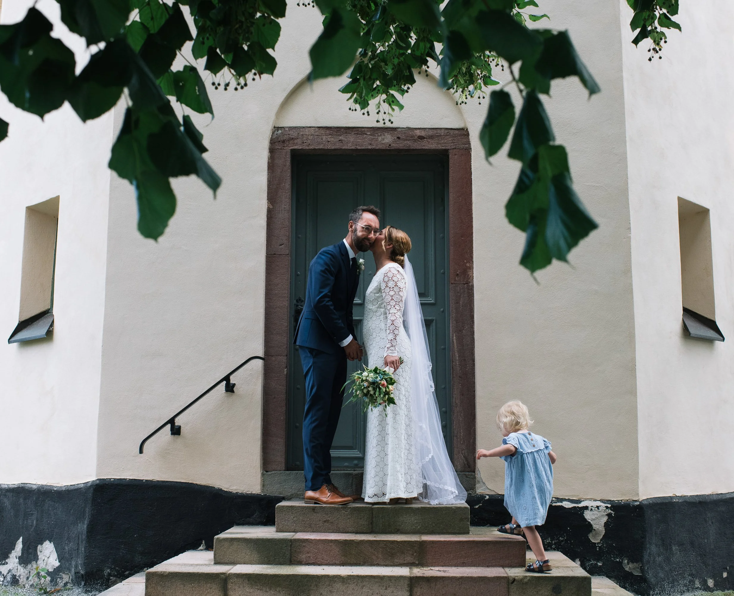 bride and groom with their children at the church getting married in Stockholm