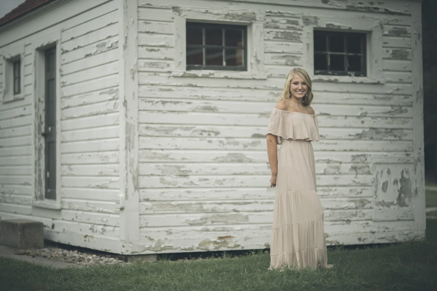Environmental portrait beside historic white cottage in Sleeping Bear Dunes.