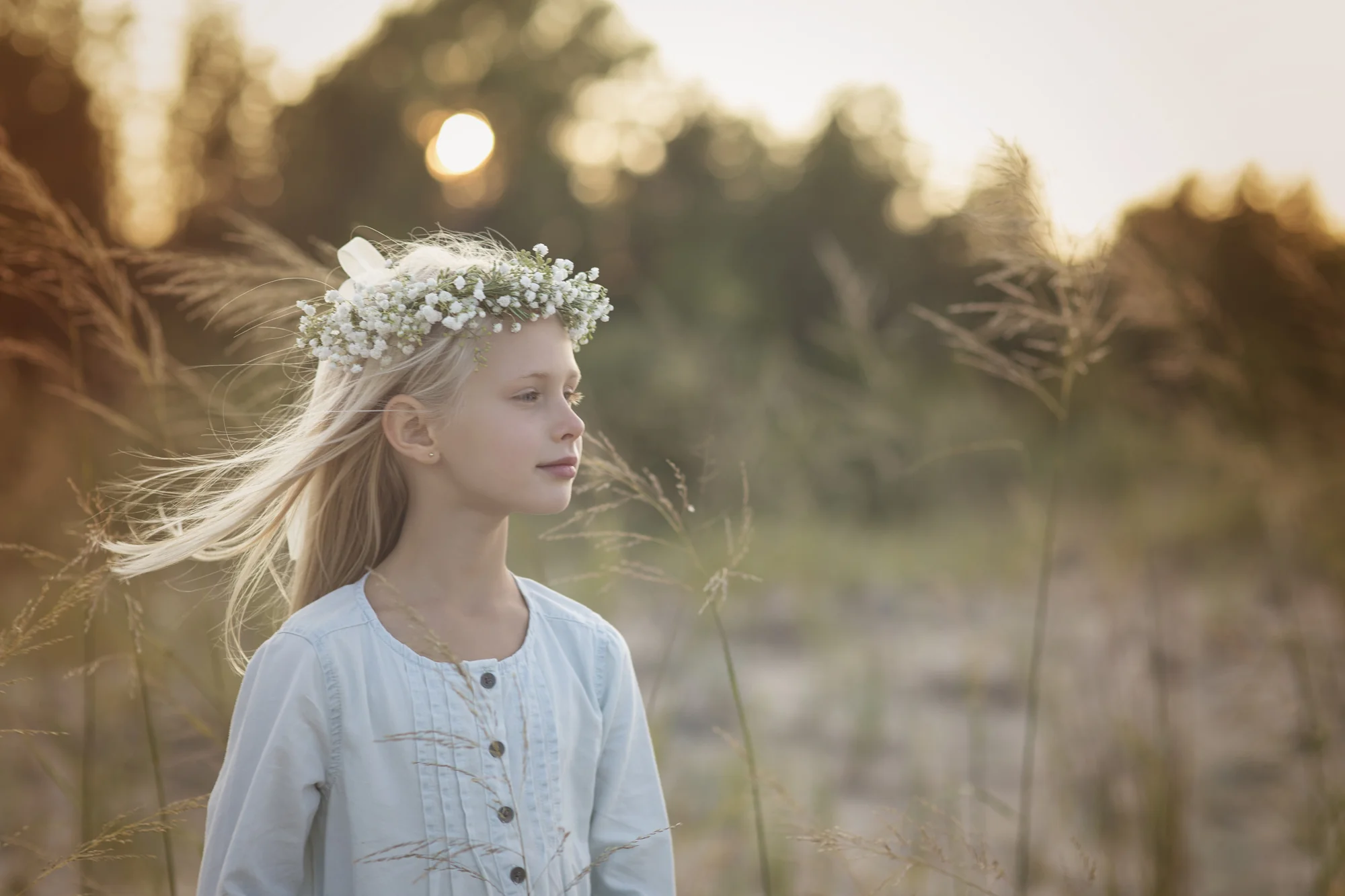 Portrait of young girl wearing flower crown at sunset.