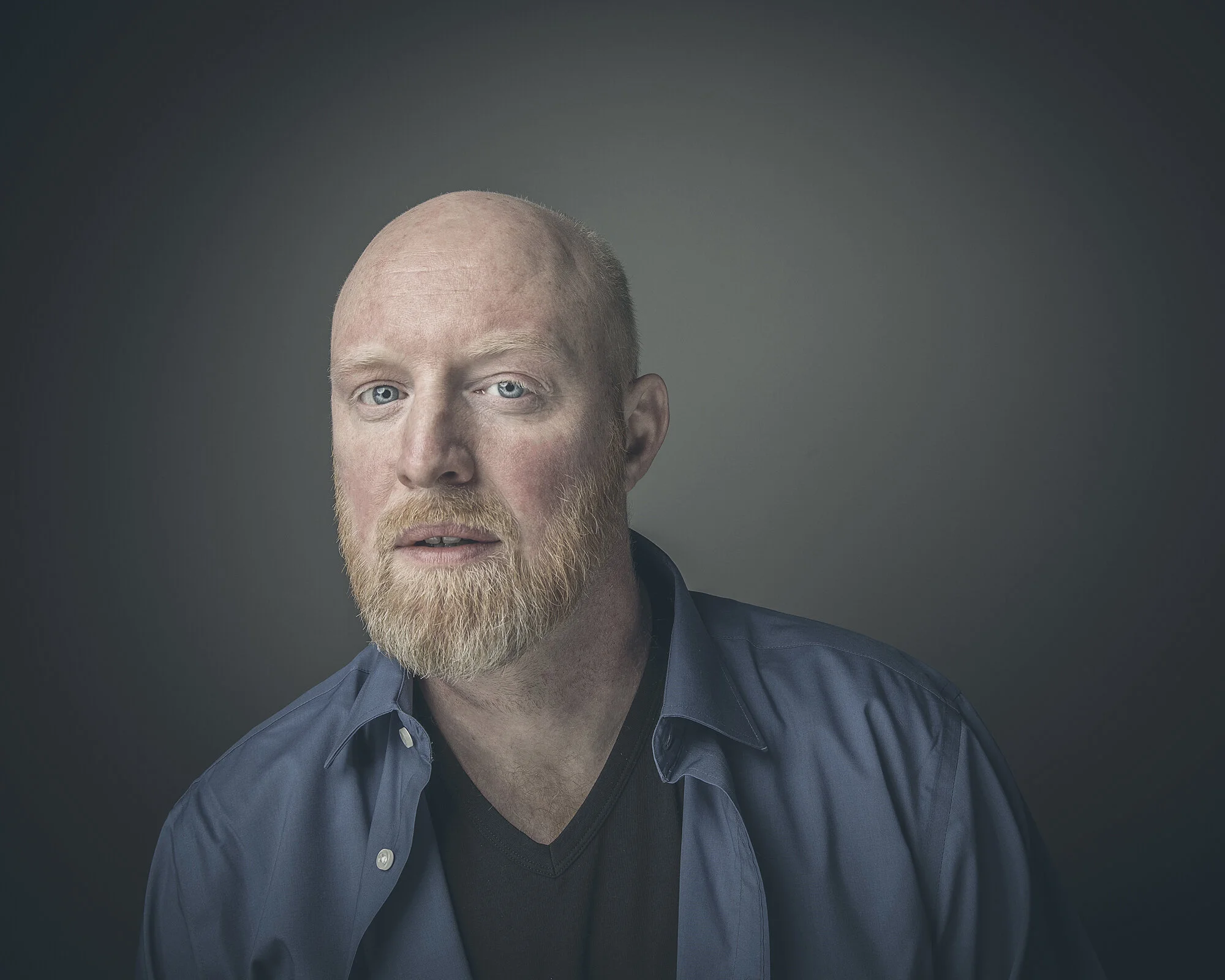 Studio portrait of bald man with beard.