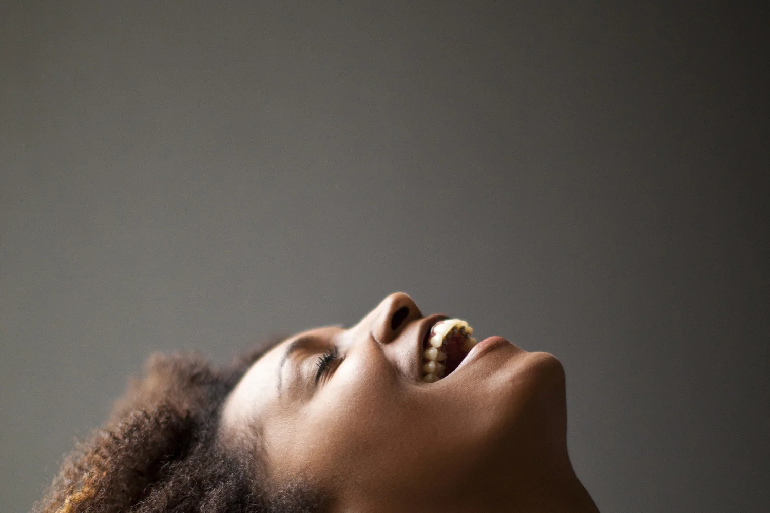 Expressive portrait of smiling woman looking upward.