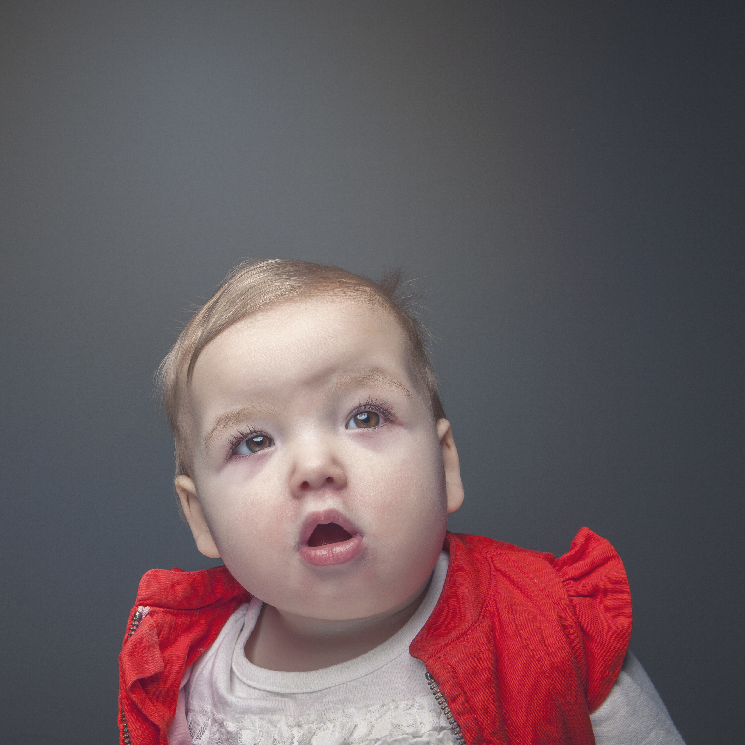 Studio portrait of toddler wearing red jacket.