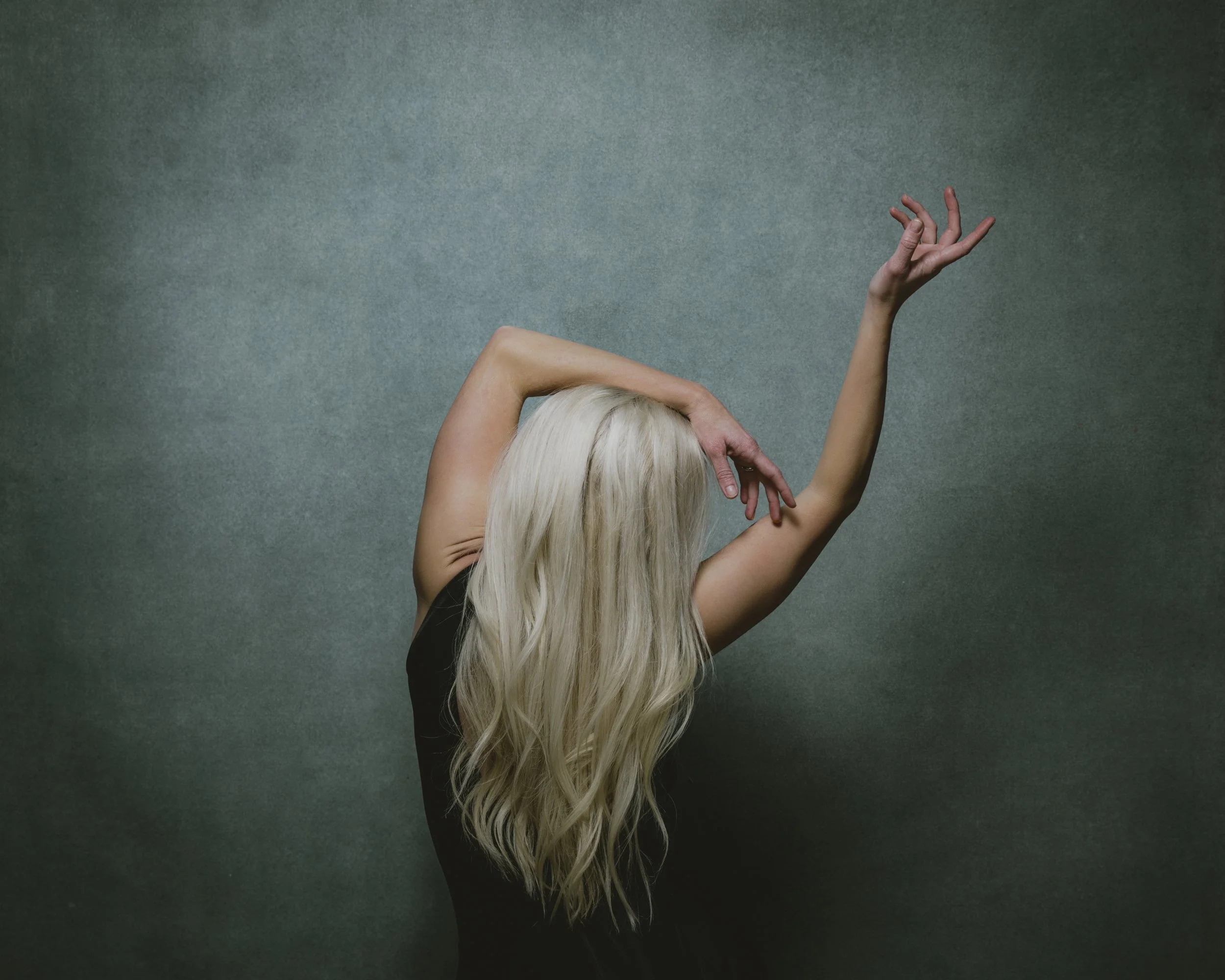 Studio portrait of a dancer with platinum blonde hair in expressive pose.