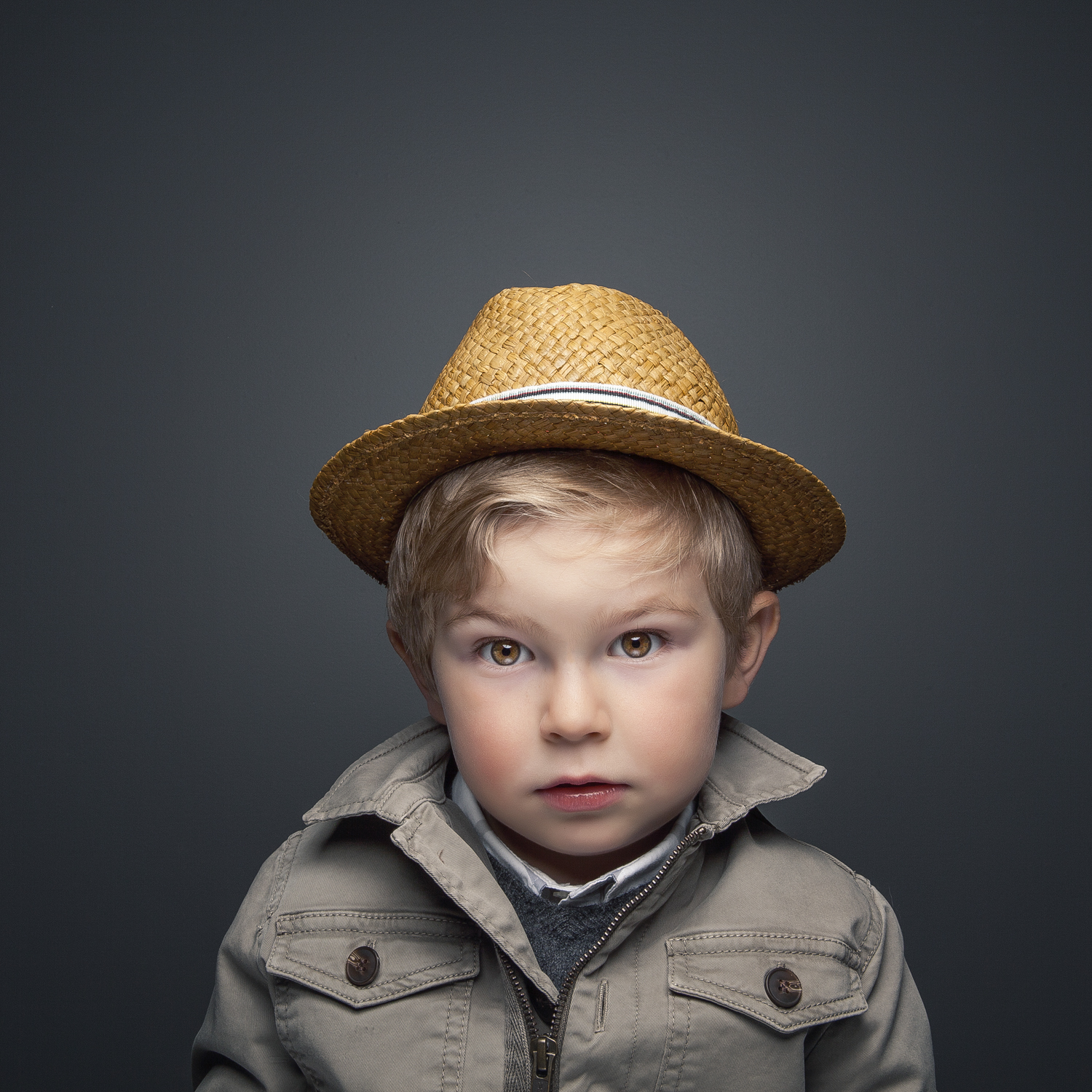 Studio portrait of young boy wearing straw hat.