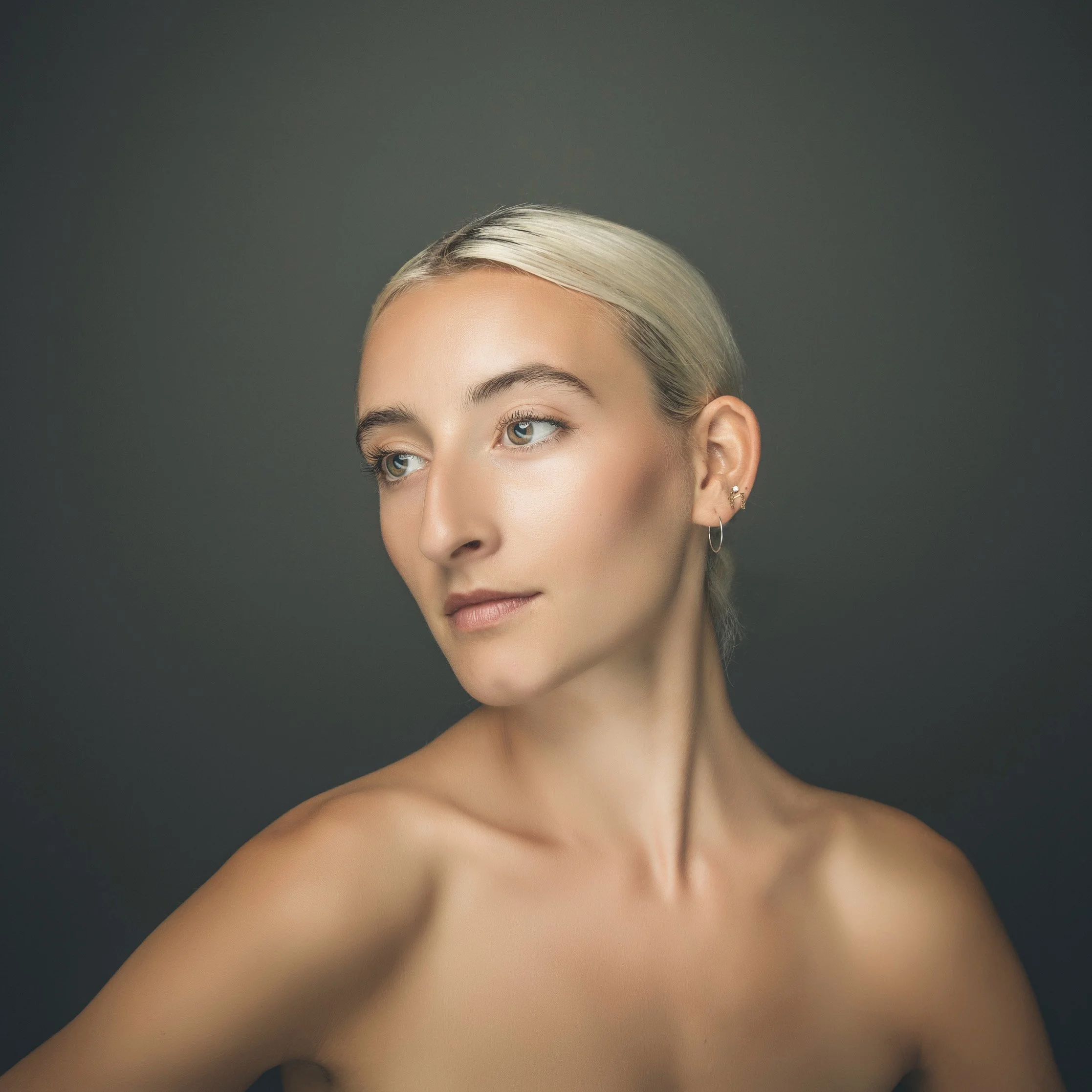 Fine art studio portrait of woman with platinum blonde hair.