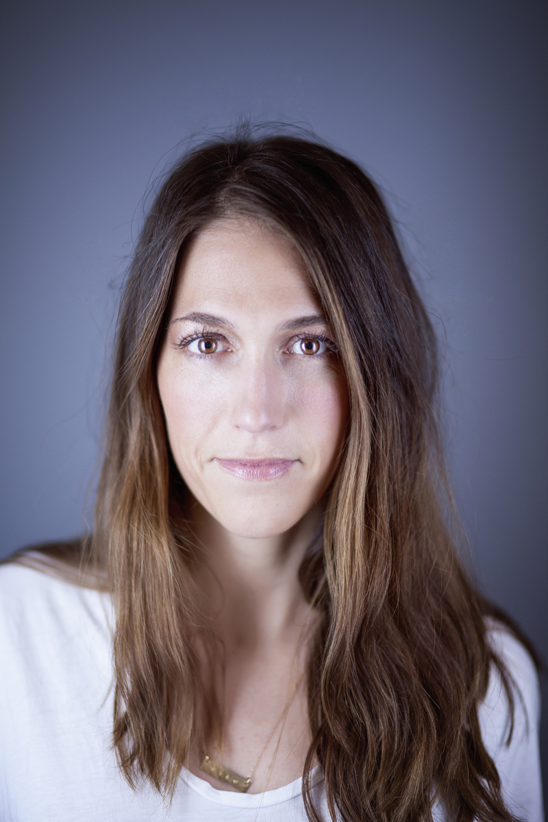 Studio portrait of woman with long brown hair.