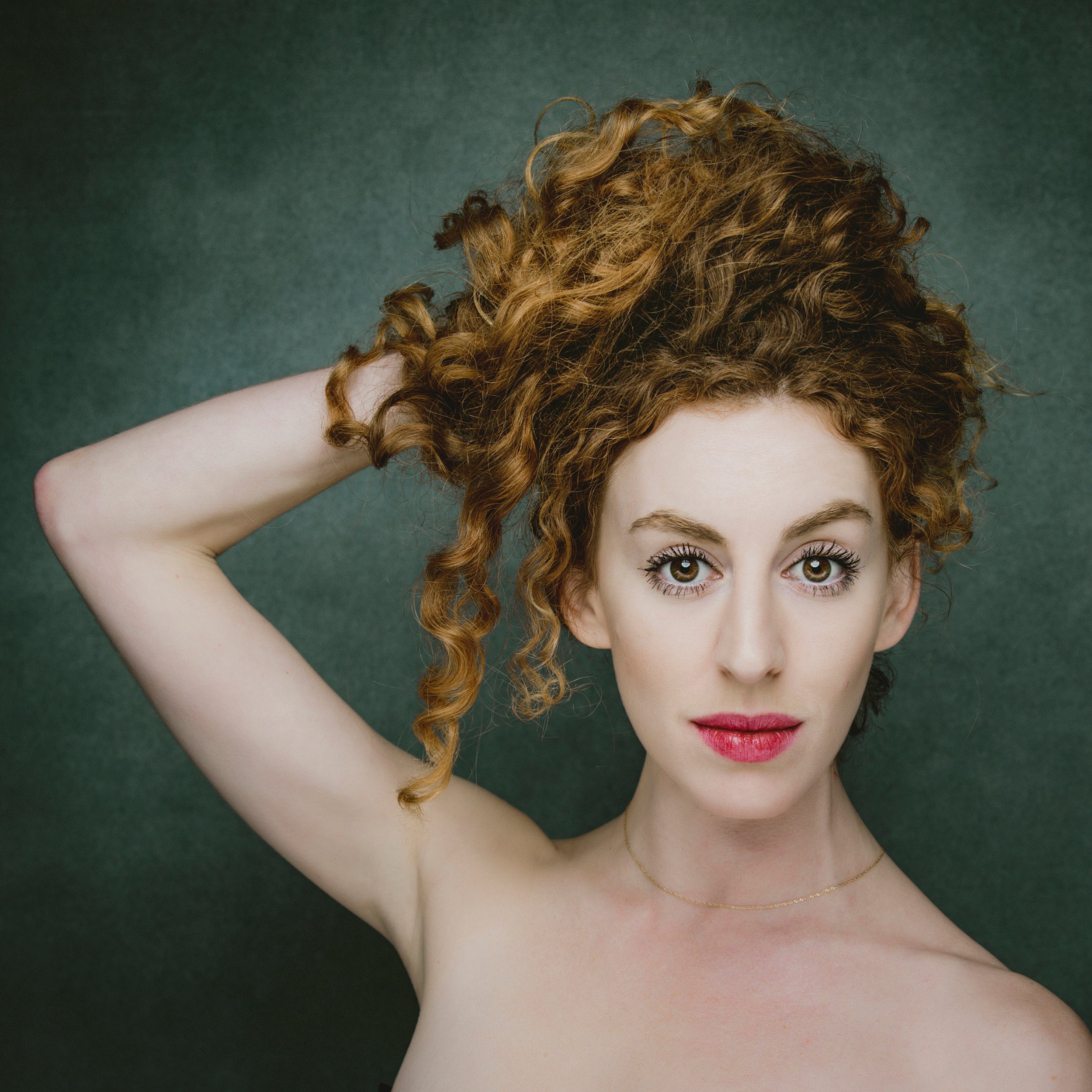 Expressive portrait of woman with curly red hair.