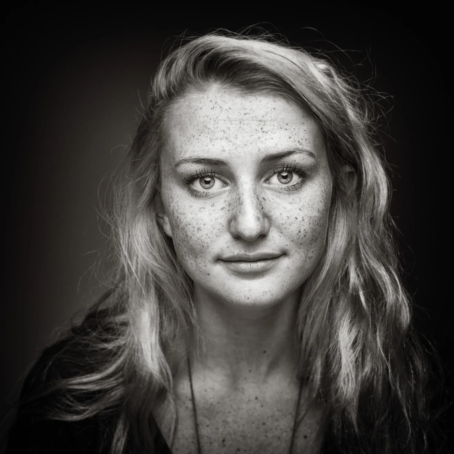 Black and white portrait of freckled woman.