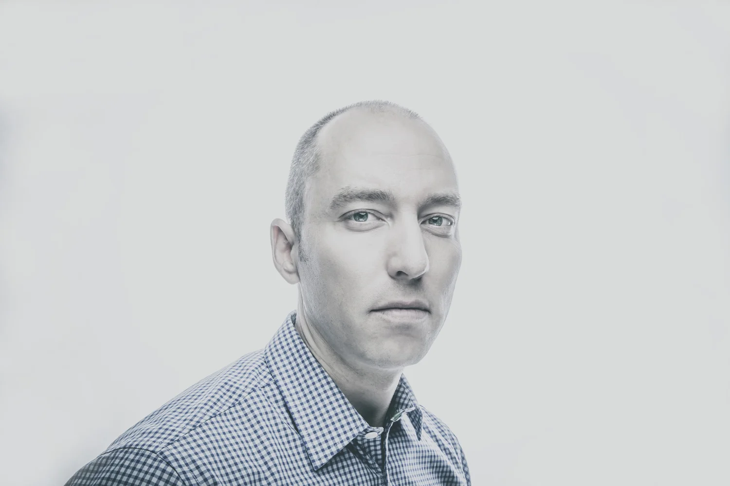 High-key portrait of bald man.