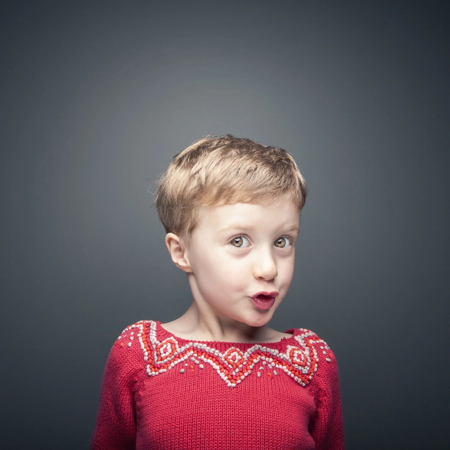 Studio portrait of young girl wearing red sweater.