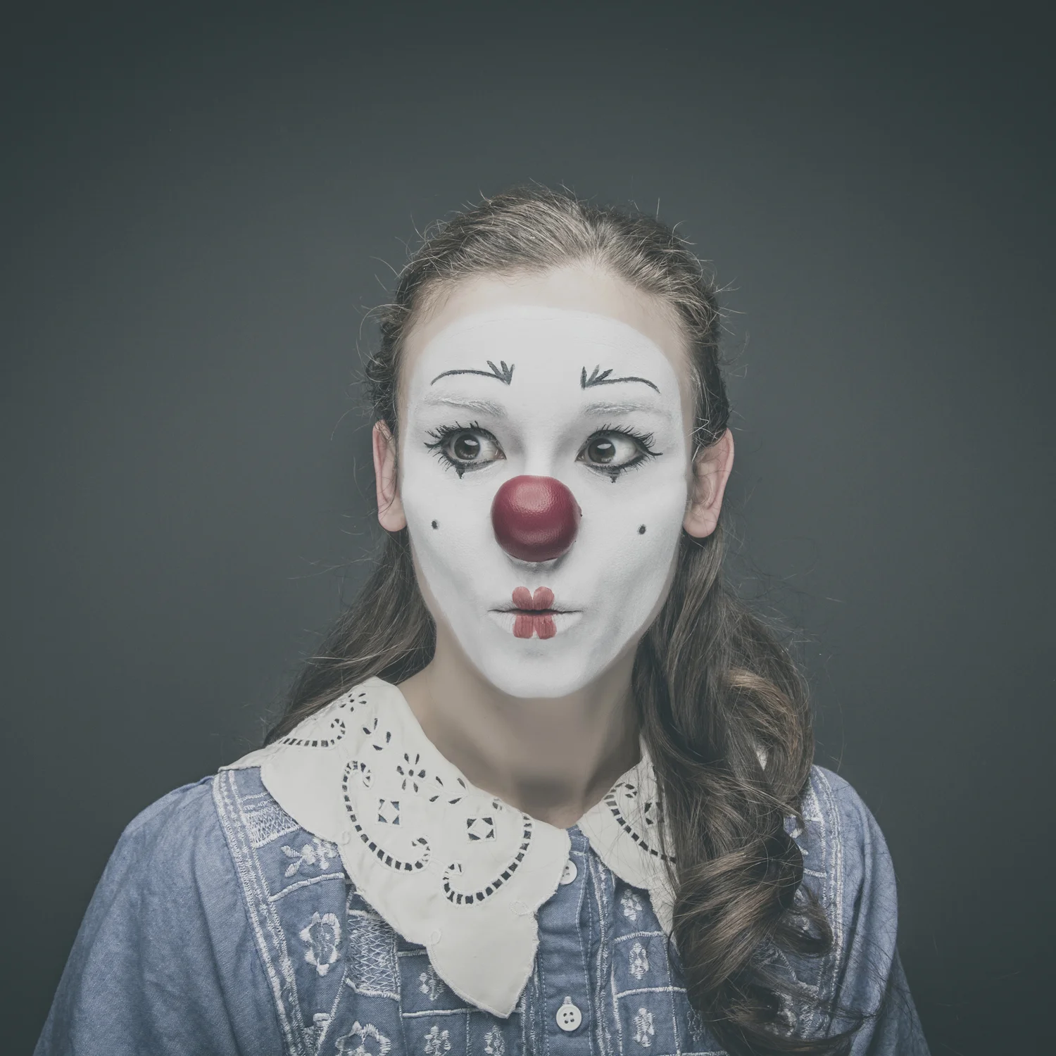 Editorial portrait of woman wearing vintage clown makeup.