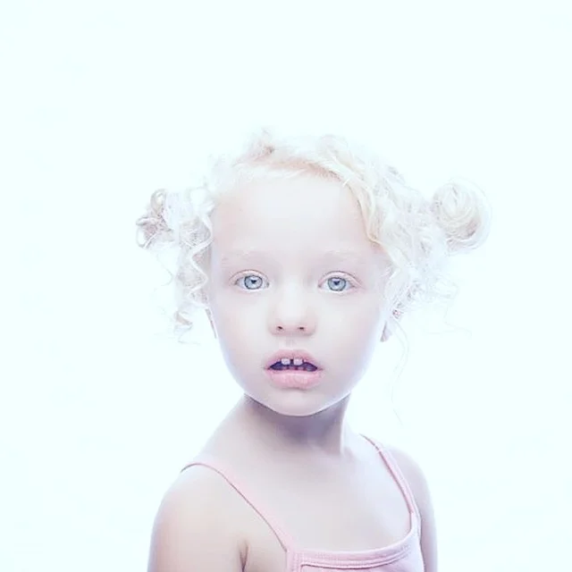 High-key portrait of young girl with platinum blonde hair.