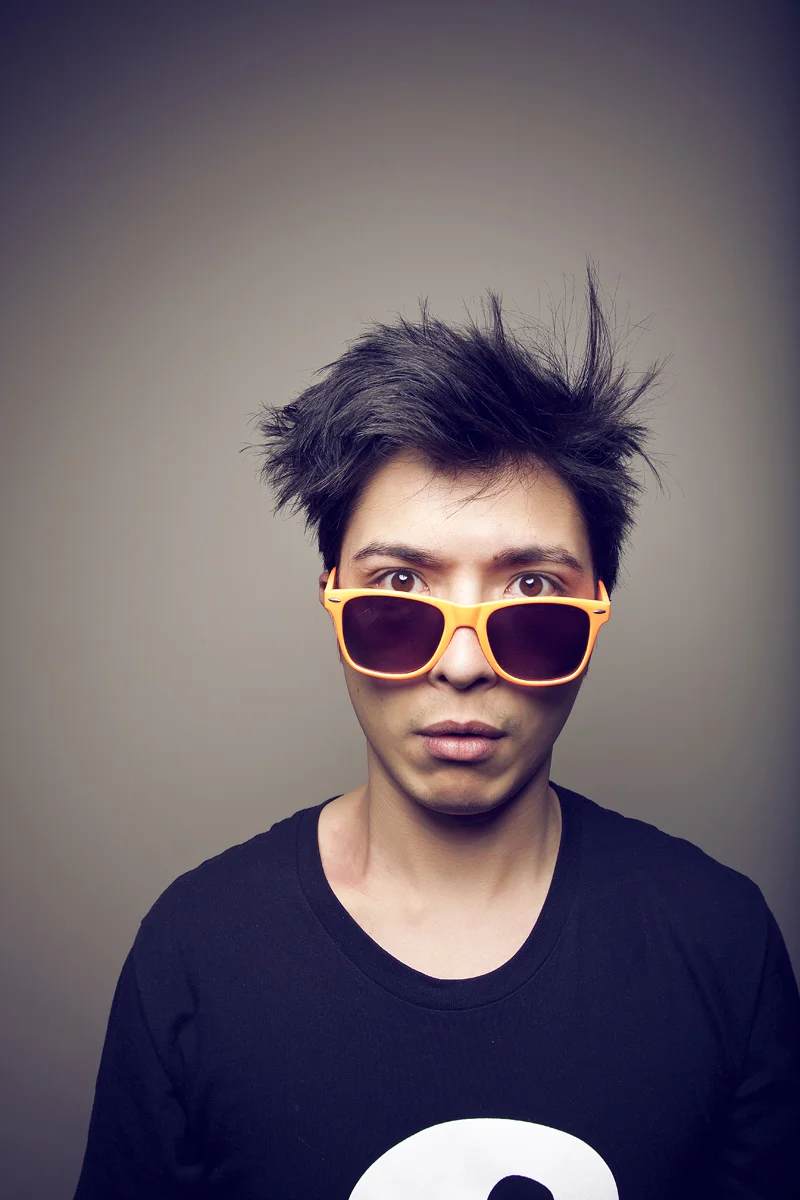 Editorial portrait of man wearing orange sunglasses.
