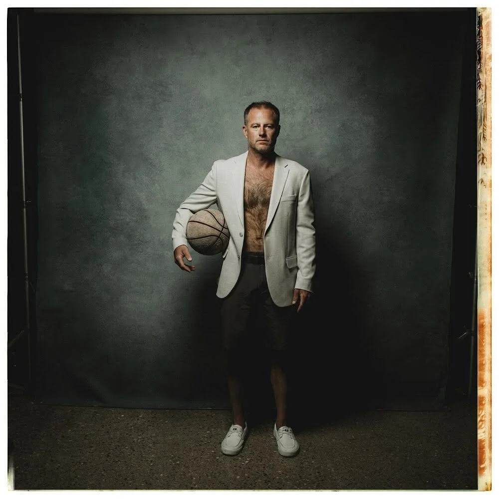 Editorial portrait of a man in studio holding basketball.
