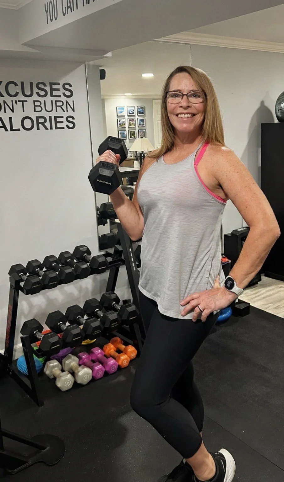 Coach Annette holding a dumbbel in her gym.