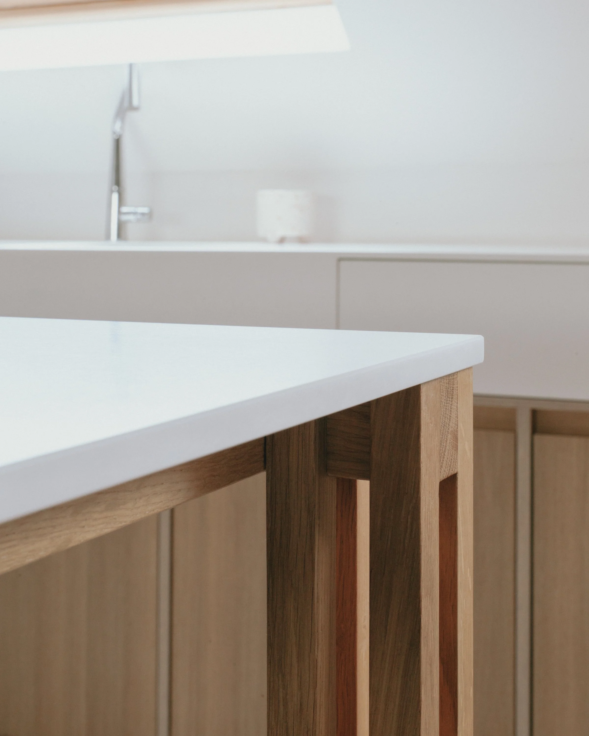 Un comptoir de cuisine en bois avec un évier blanc intégré, visible en partie dans ce plan.