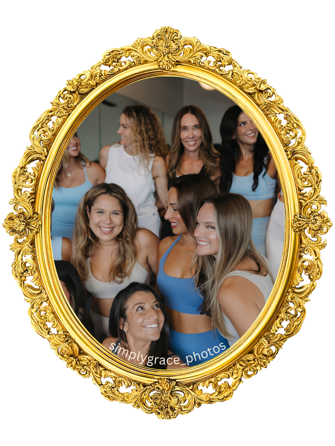 A group of women smiling and posing for a photo through a decorative gold ornate mirror frame, with some women in workout attire and others in casual clothing.