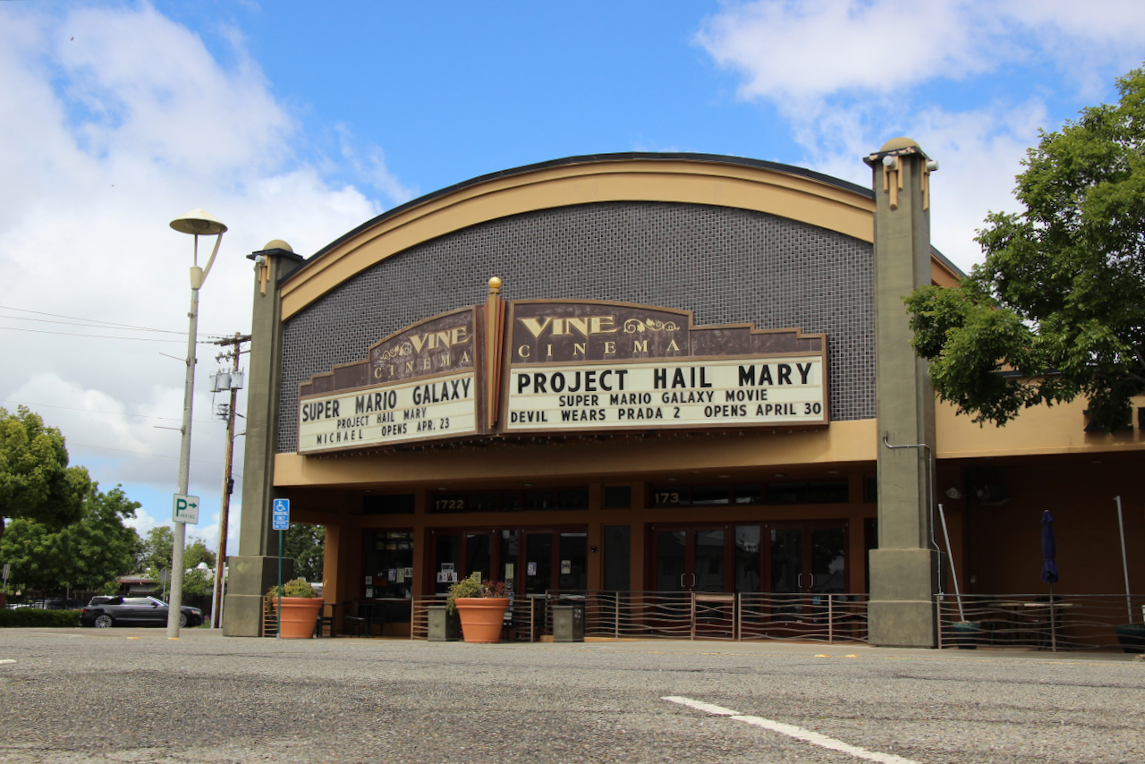 Vine Cinema and Alehouse showing movie titles on a marquee including "Super Mario Galaxy" and "Project Hail Mary" with a blue sky and trees around.