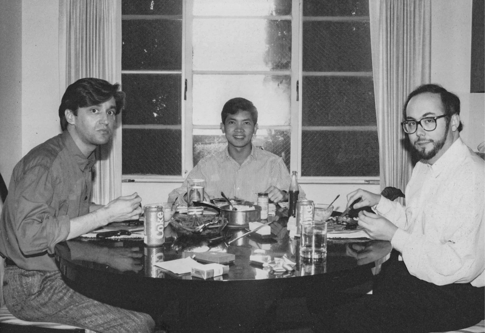 Mark Schulte, Tri Tran, and Doug Endicott at a table together, 1989.
