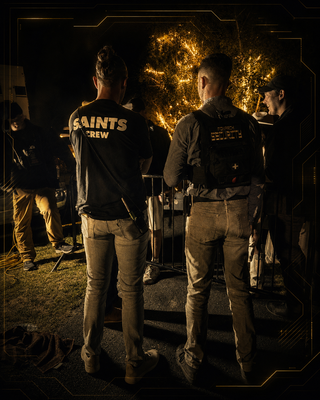 Group of people, including Monarch security personnel, gathered at night