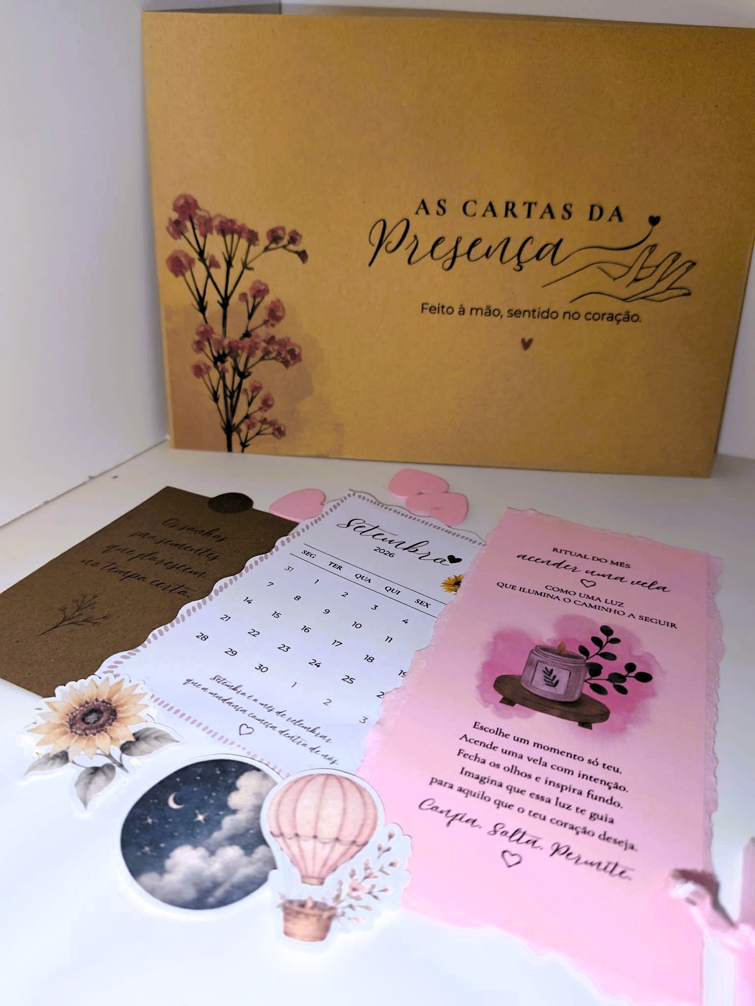 Imagem com diversos bilhetes e cartões decorativos, incluindo um calendário de setembro de 2026, um bilhete e uma mensagem de inspiração em papel rosa, além de adesivos de papelaria como um balão, uma flor e uma representação do céu.