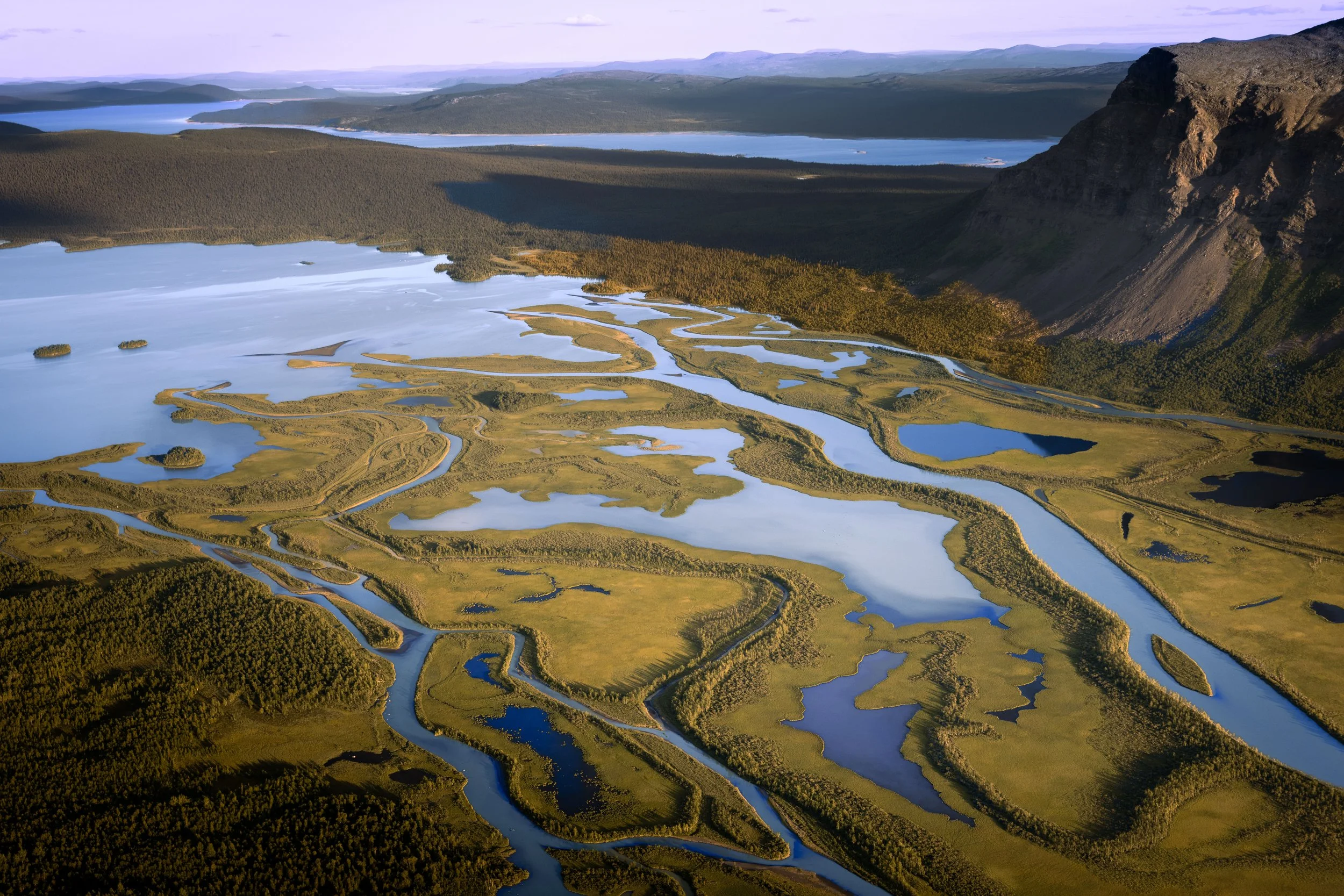 Aerial view of Rapadalen valley in Sarek National Park, Sweden, with winding river and dramatic mountain landscape