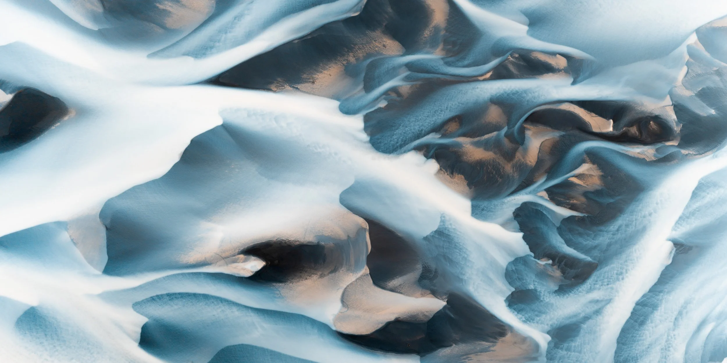 Panoramic view of a blue glacial river flowing through extensive sediment plains in Iceland