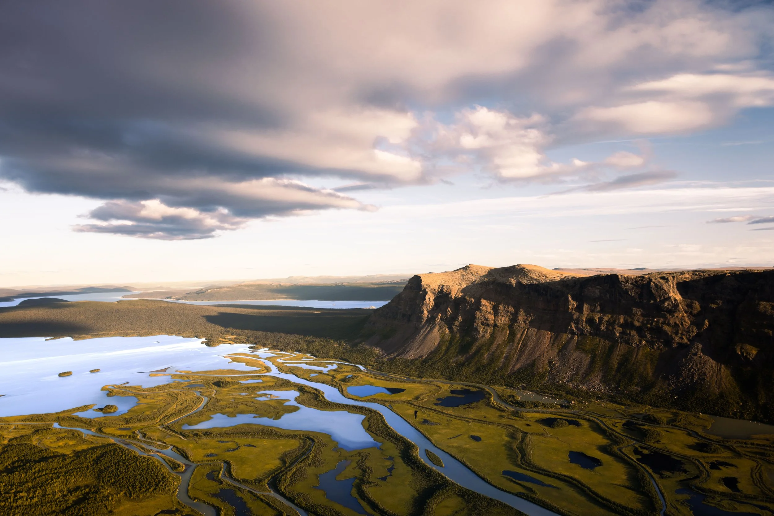 Remote wilderness landscape in Rapadalen, with green valleys, mountains and the winding Rapa River