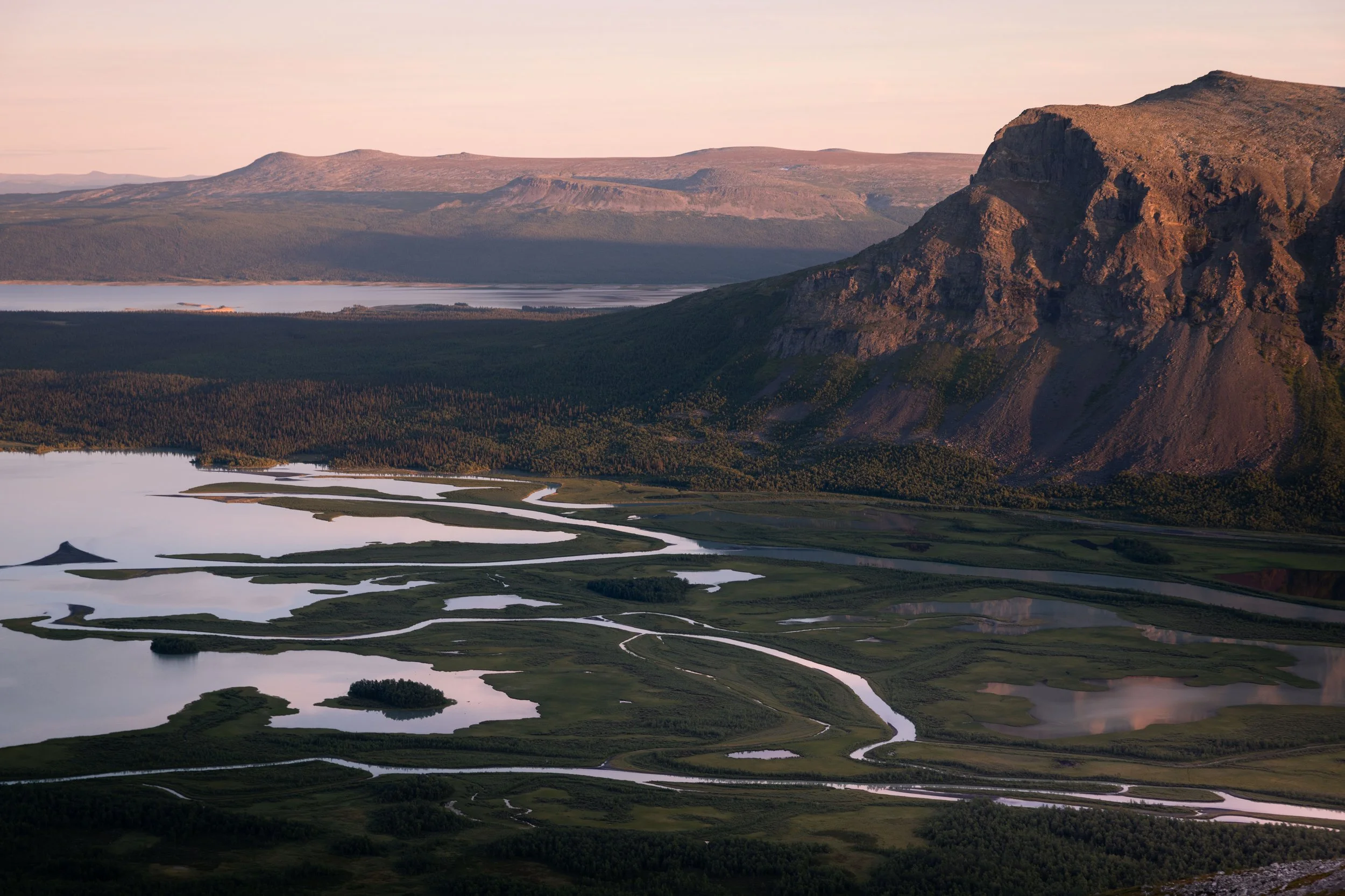 Rapa River flowing through Rapadalen valley beneath the mountains of Sarek National Park