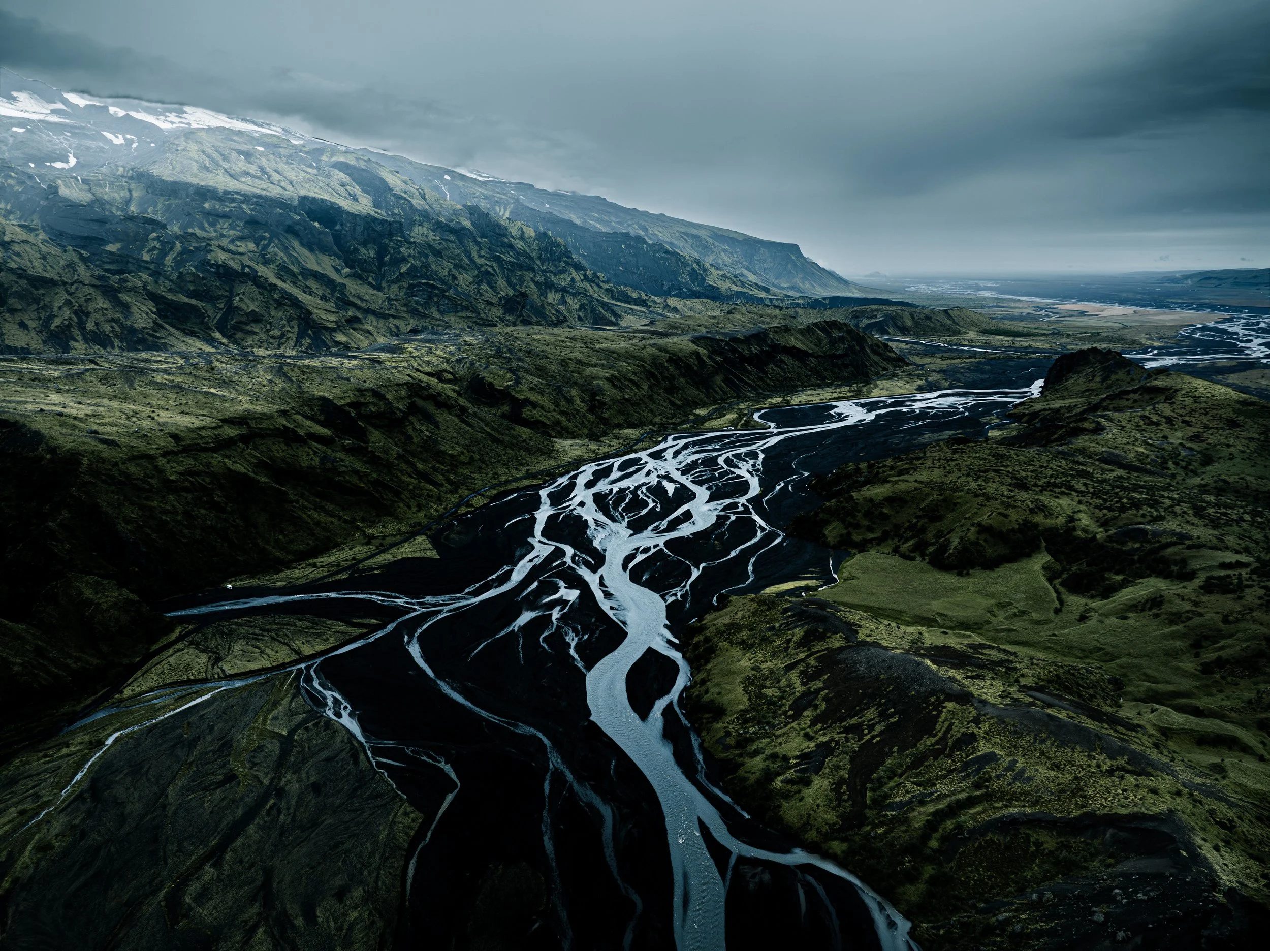 Braided glacial rivers winding through the green mountains of Þórsmörk, Iceland