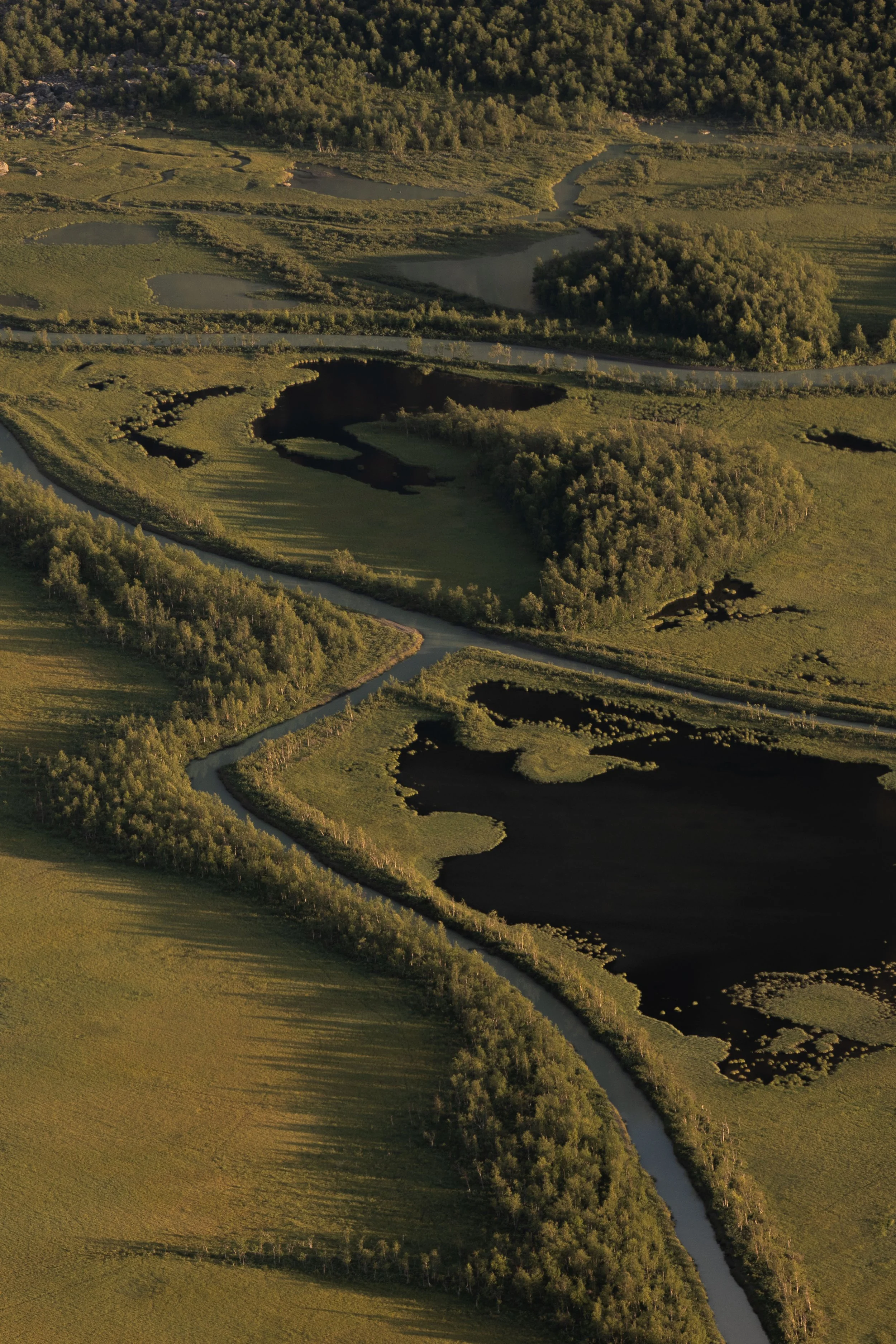 Scenic aerial photography of Rapadalen surrounded by rugged mountains and dense Scandinavian wilderness
