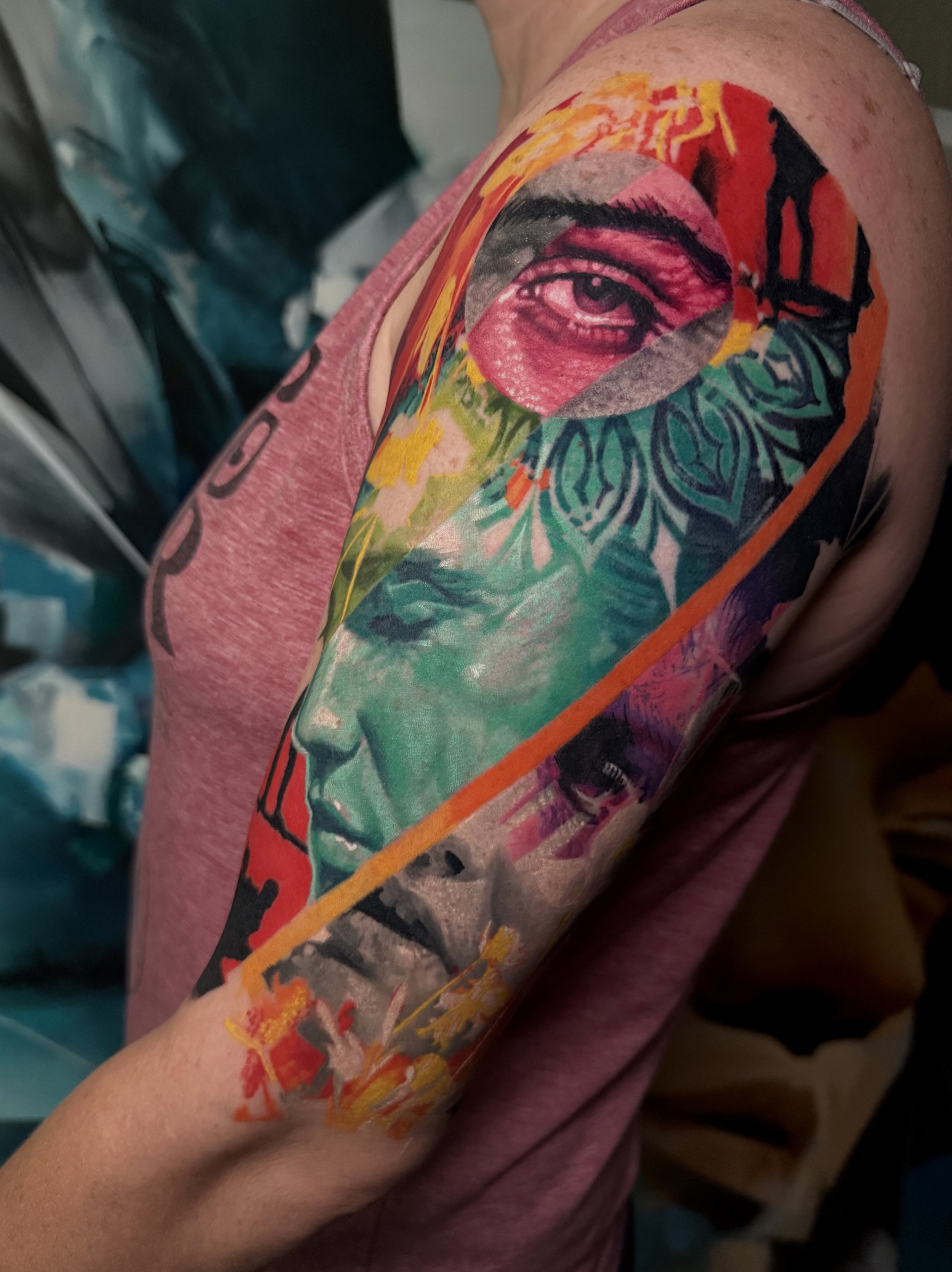 Colorful tattoo of a man's eye with vibrant abstract designs on upper arm.