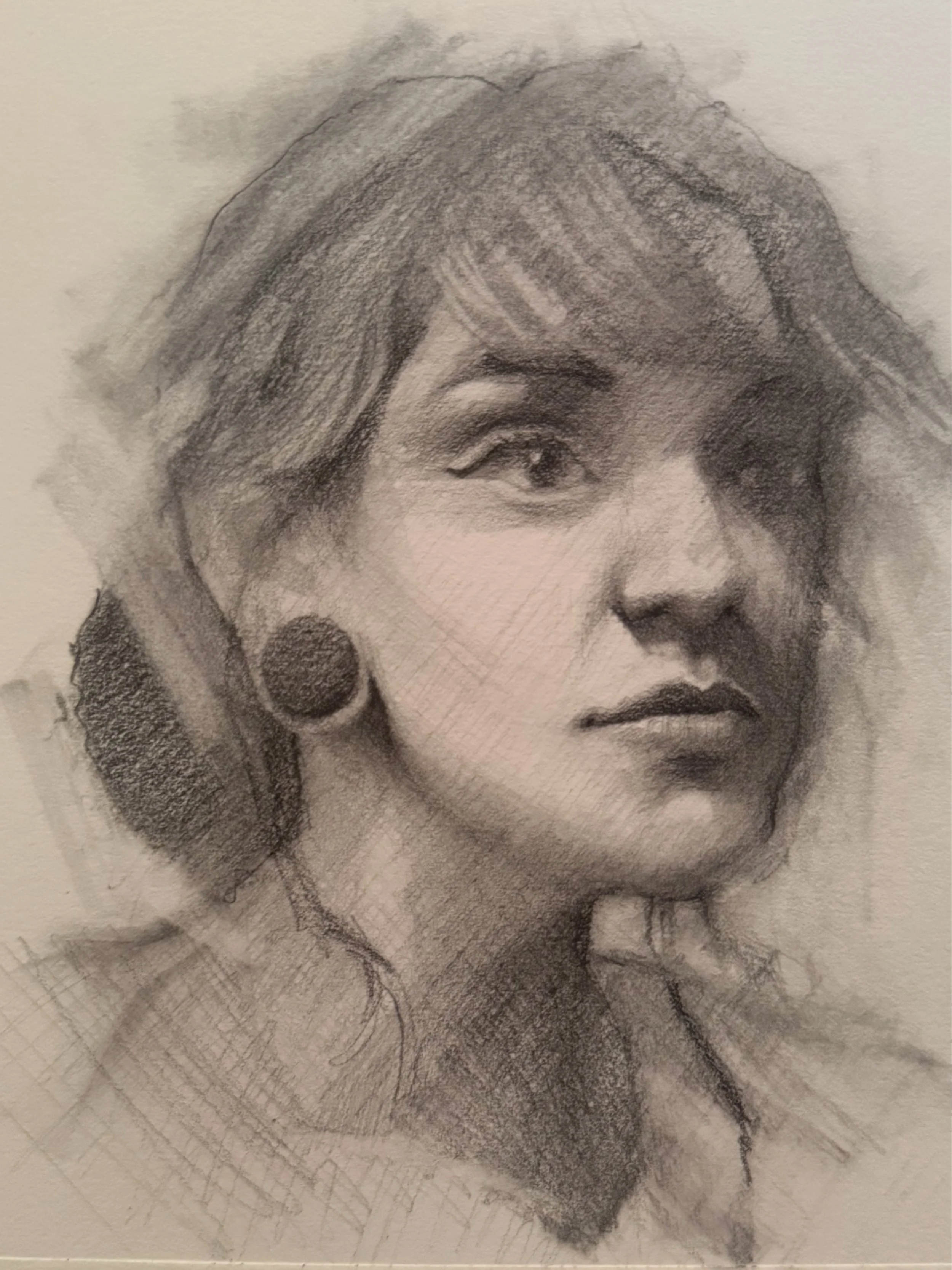 A detailed pencil sketch of a woman with styled hair, big earrings, and makeup, showing her face turned slightly to the side.