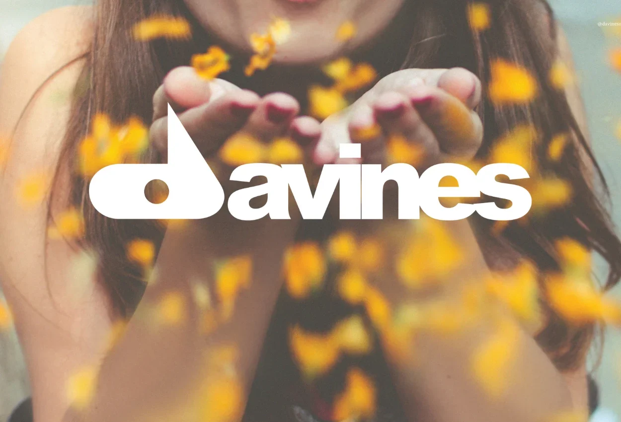 Person blowing yellow flower petals from their hands.