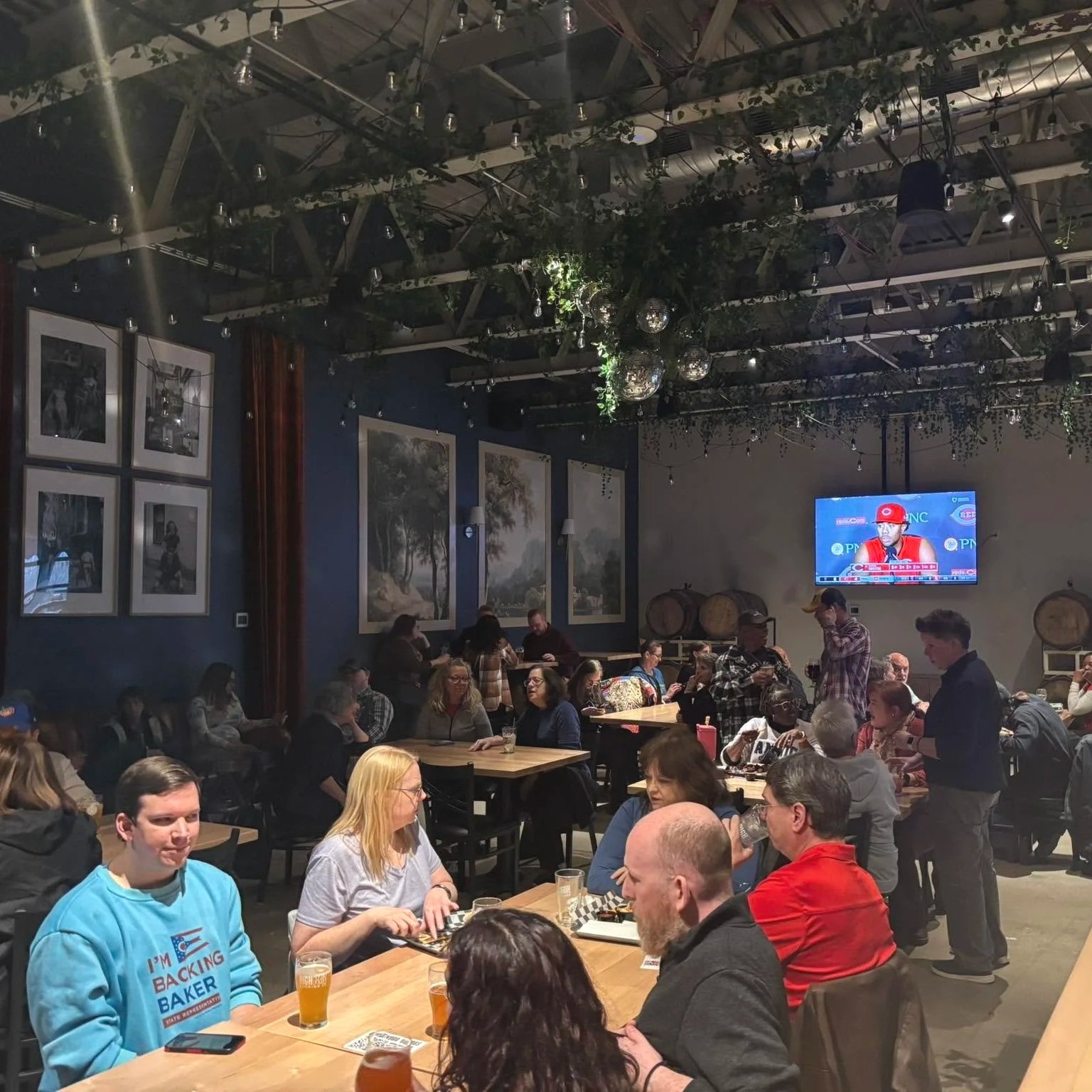 group of people at tables in a brewery setting