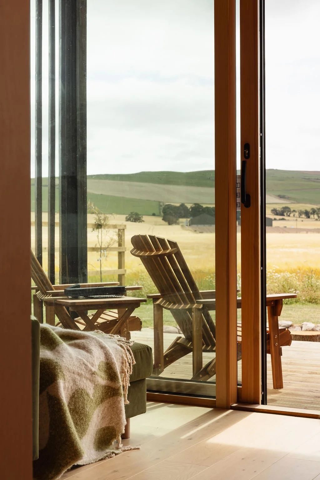 View of sun loungers from inside of a cosy cabin.
