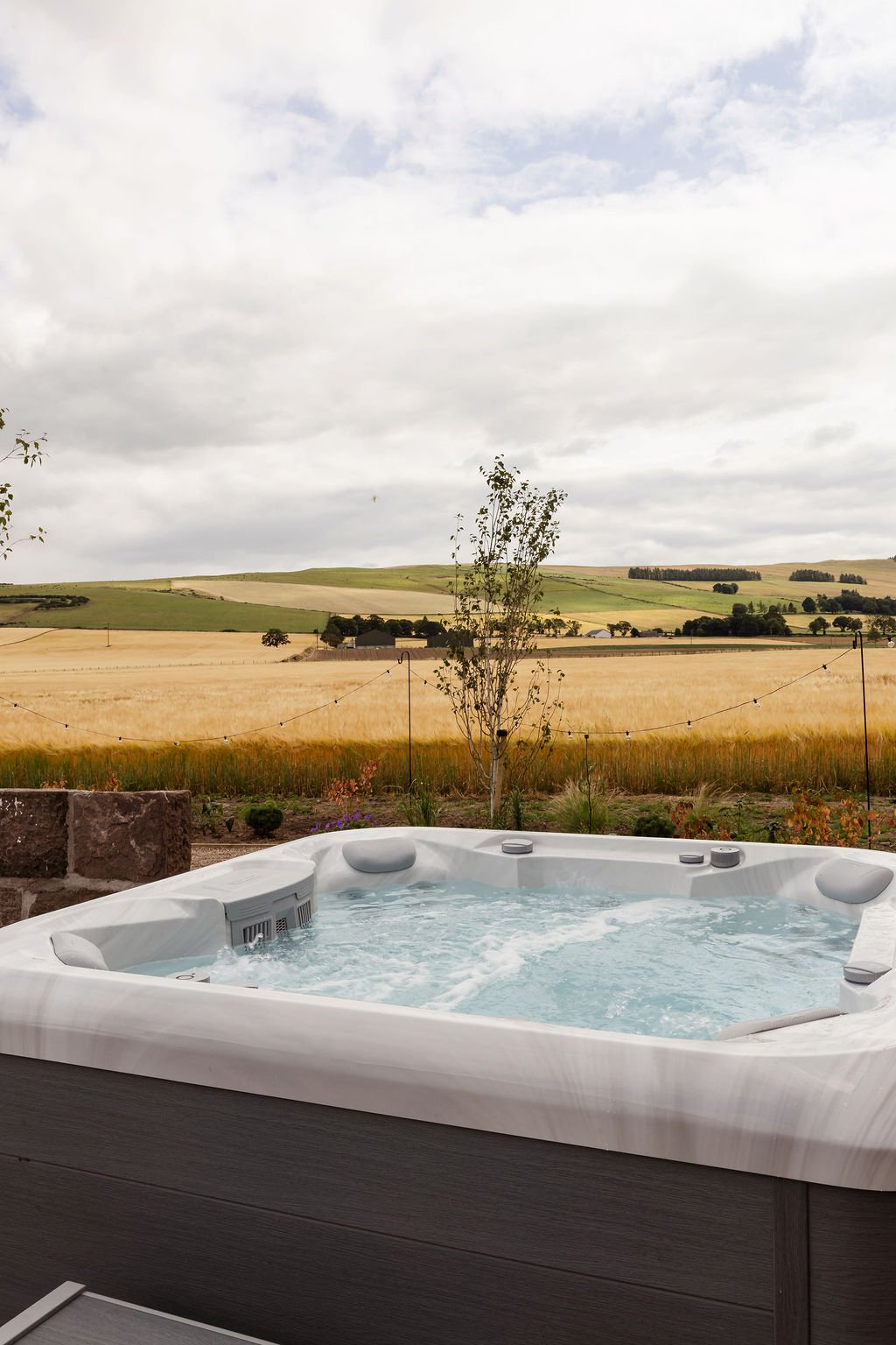 Hot tub with bubbles on. Views over rolling hills.