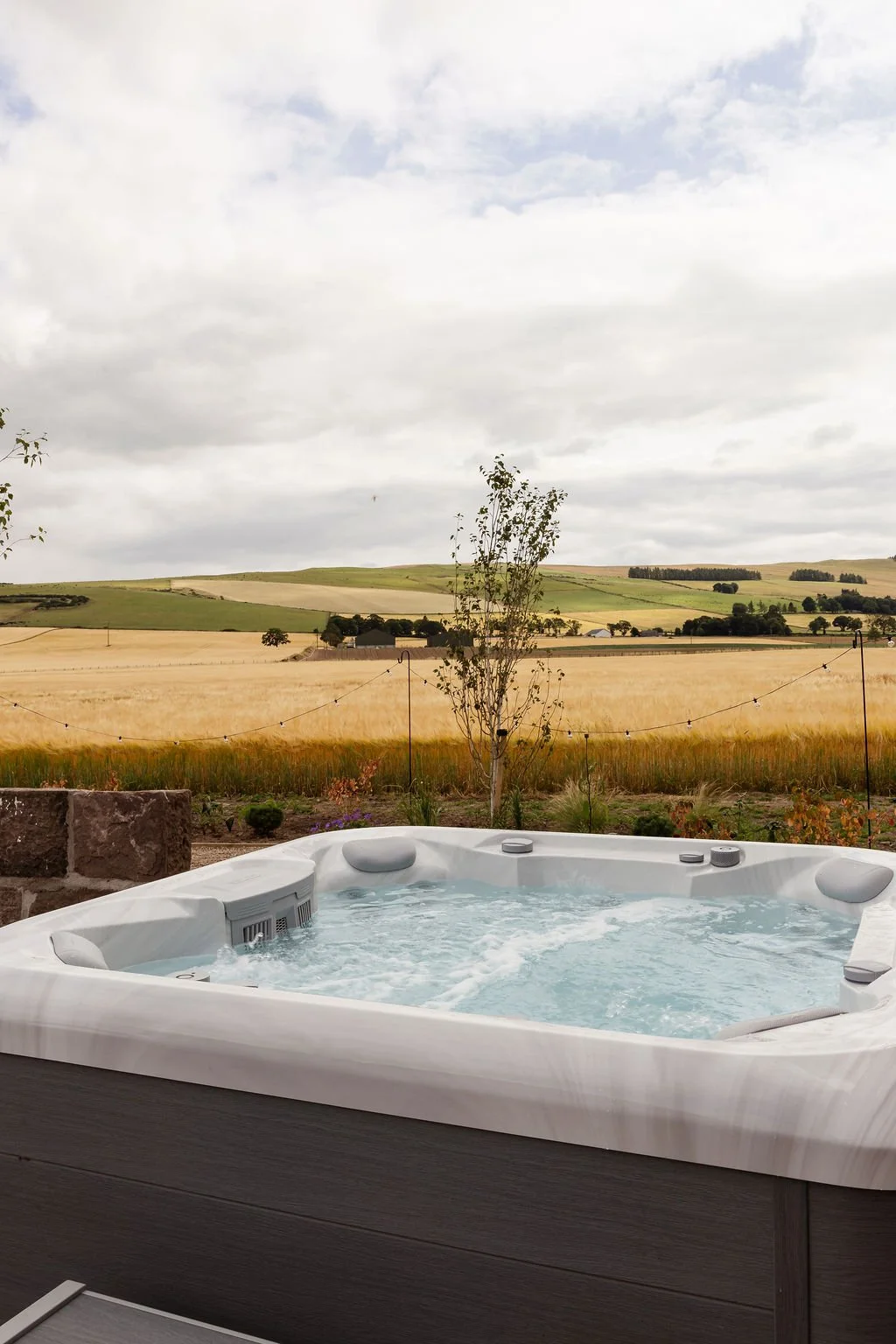 Jacuzzi with bubbles on. Framed with Angus hill views.