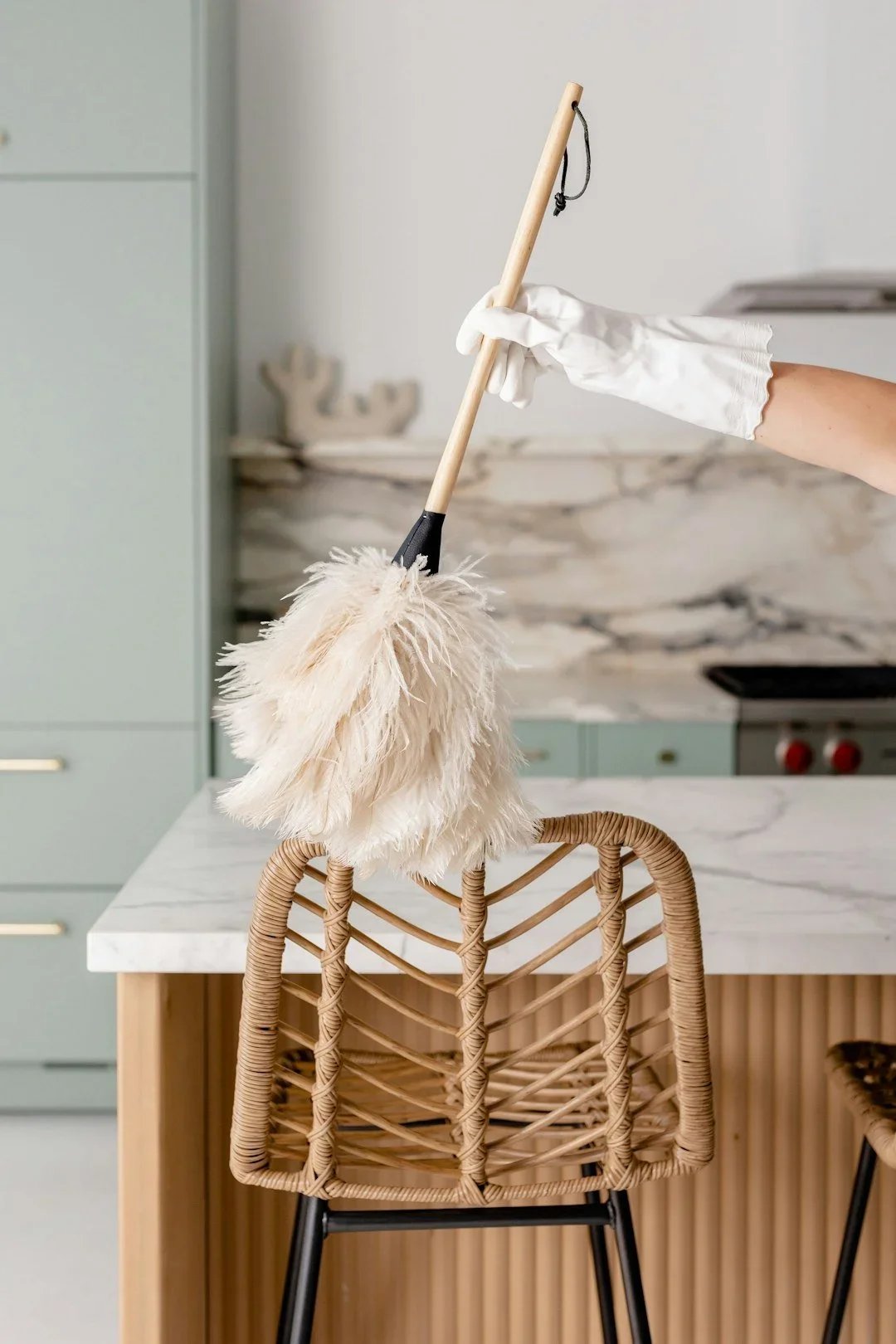 Professional Duluth house cleaner dusting a dining chair during a residential green cleaning service