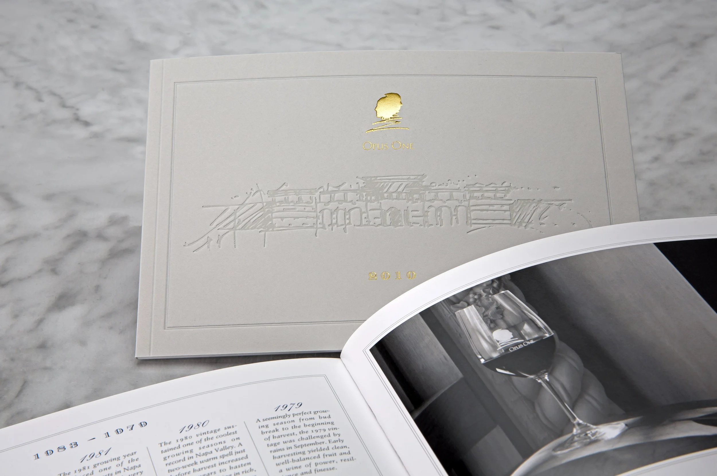 A booklet with embossed gold lettering and image on the cover, featuring a building and a silhouette of a person, with text indicating the year 2010.