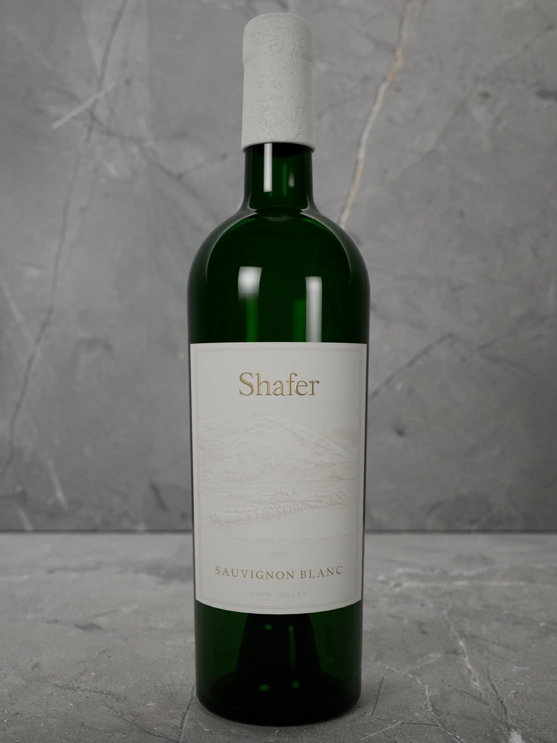 Green wine bottle with white label that reads "Shafer" and "Sauvignon Blanc" on a gray marble surface.