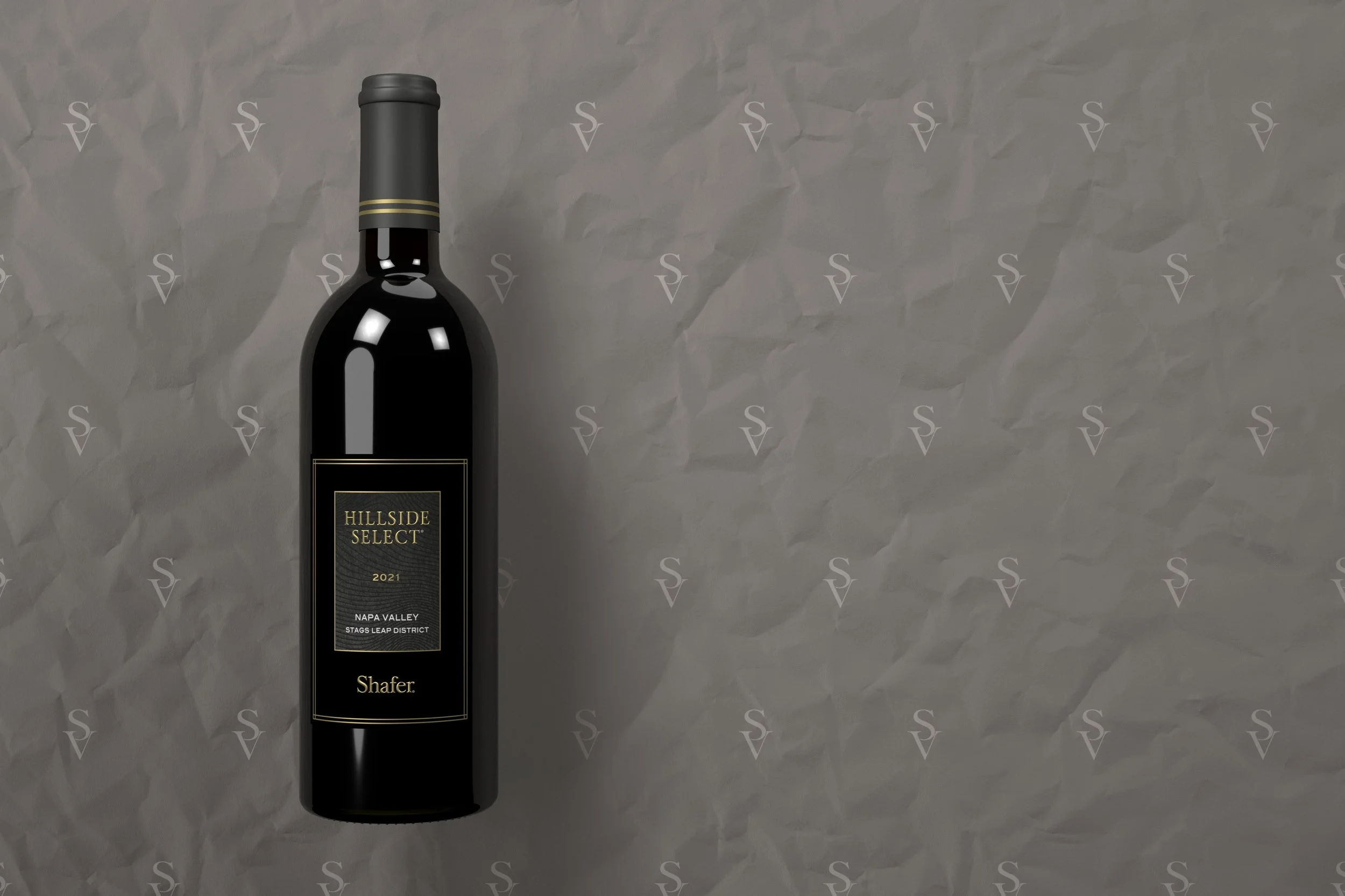 A wine bottle with a black label and gold accents placed on crumpled gray paper background, with the label reading 'Hillside Select 2021 Napa Valley Stags Leap District'.