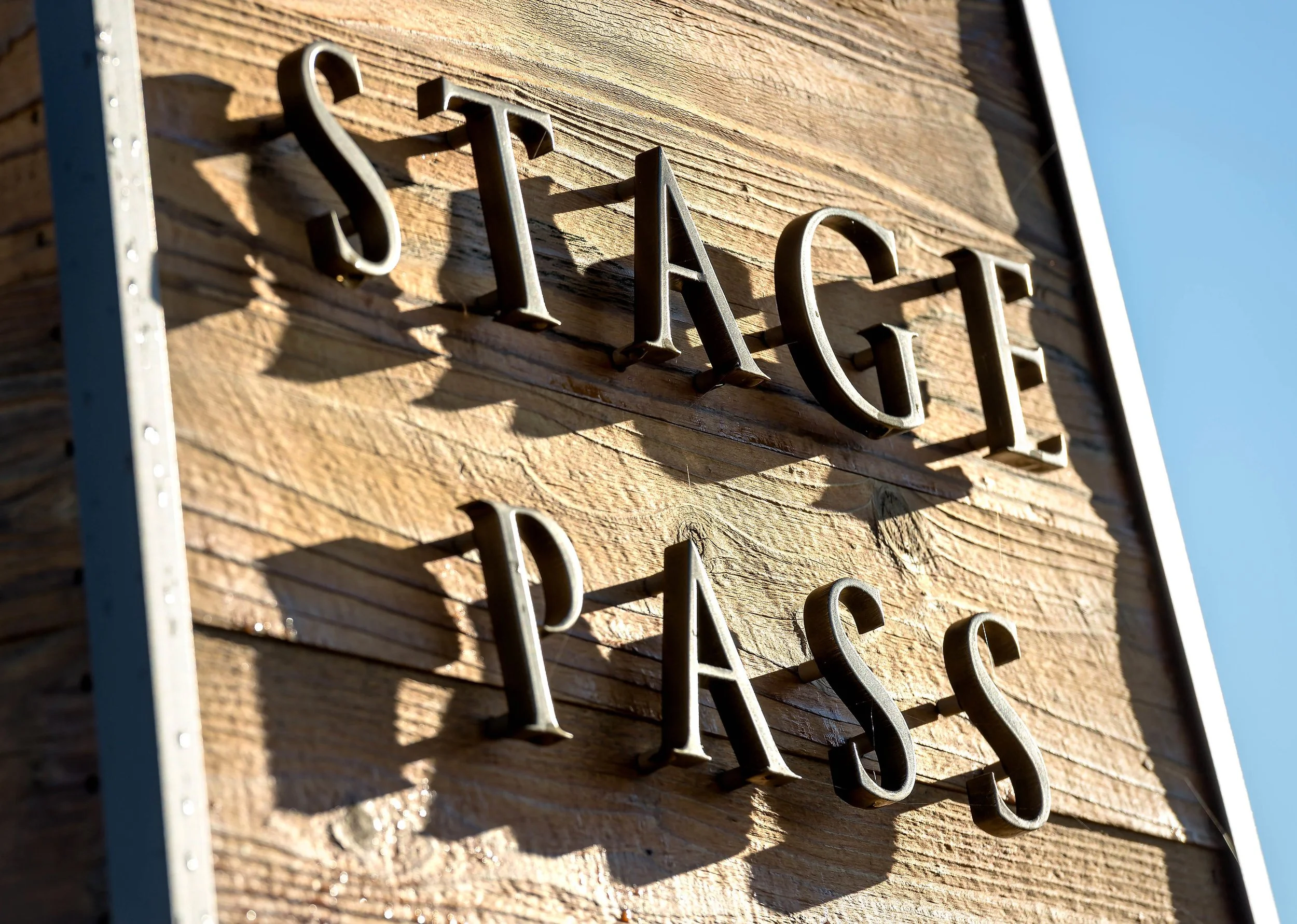 Close-up of a wooden sign with metal letters spelling 'STATE' attached to the wood surface.