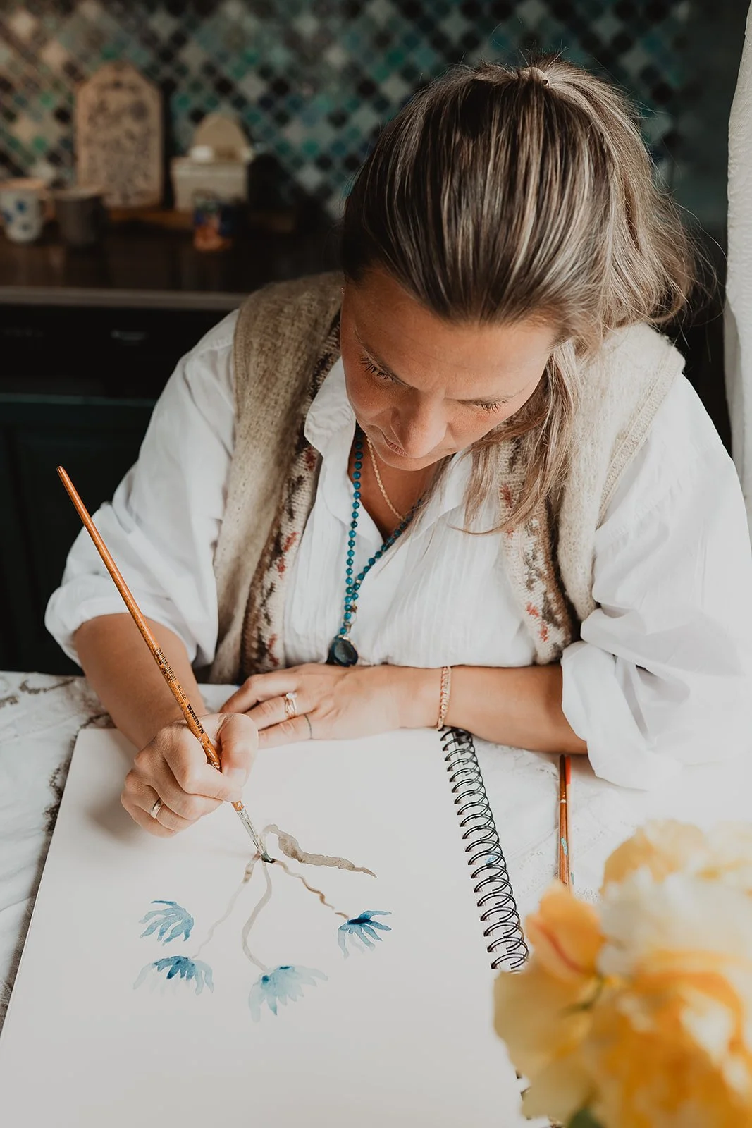 Artist Ieva Rudzite of Nordic Duck hand painting botanical artwork in watercolor, creating original motifs for surface pattern, wallpaper and textile design.