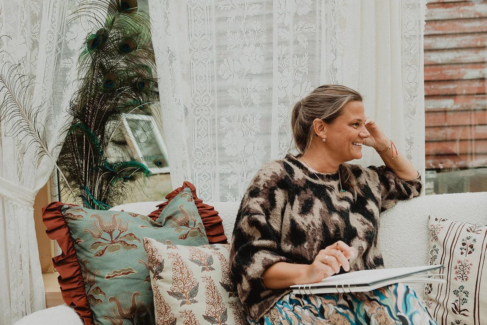 Artist and surface pattern designer Ieva Rudzite of Nordic Duck smiling and drawing by hand in her rural Norway home, creating botanical artwork for wallpaper and textiles.